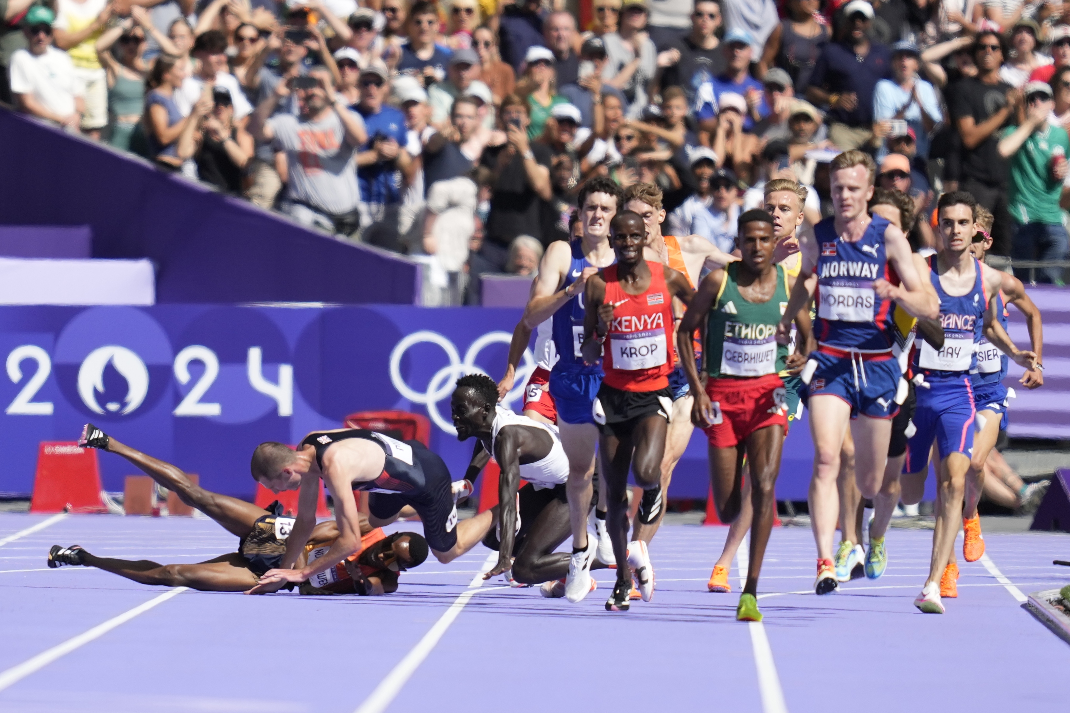 Runners fall in their heat of the men's 5000-meters at the 2024 Summer Olympics, Wednesday, Aug. 7, 2024, in Saint-Denis, France. 
