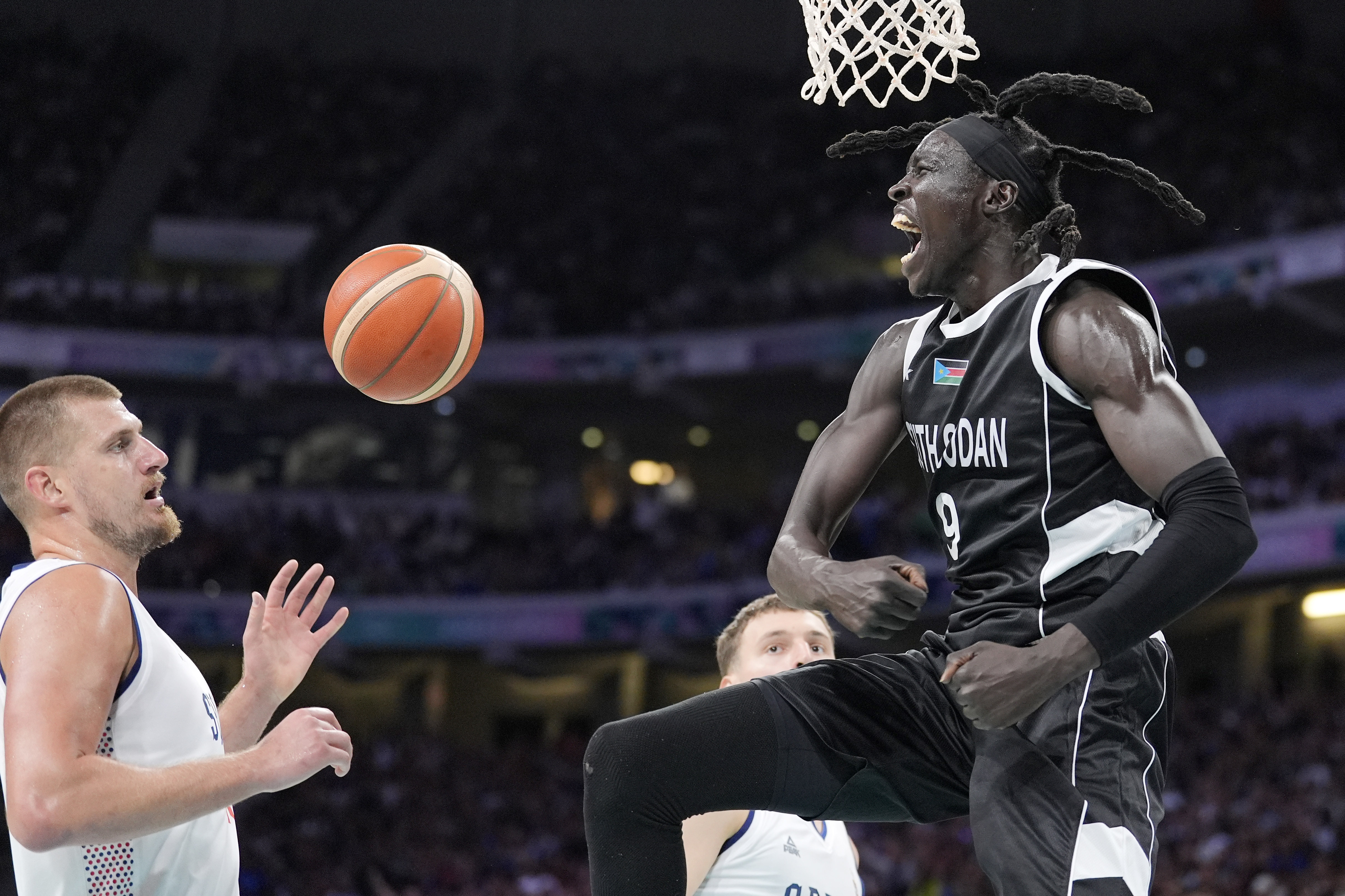 South Sudan's Wenyen Gabriel, right, celebrates after dunking as Serbia's Nikola Jokic watches during a men's basketball game at the 2024 Summer Olympics, Saturday, Aug. 3, 2024, in Villeneuve-d'Ascq, France. 