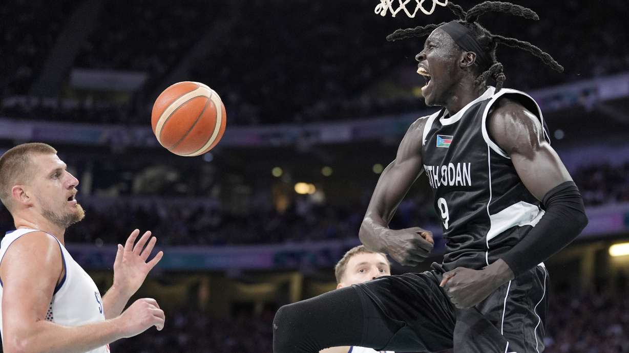 South Sudan's Wenyen Gabriel, right, celebrates after dunking as Serbia's Nikola Jokic watches during a men's basketball game at the 2024 Summer Olympics, Saturday, Aug. 3, 2024, in Villeneuve-d'Ascq, France.