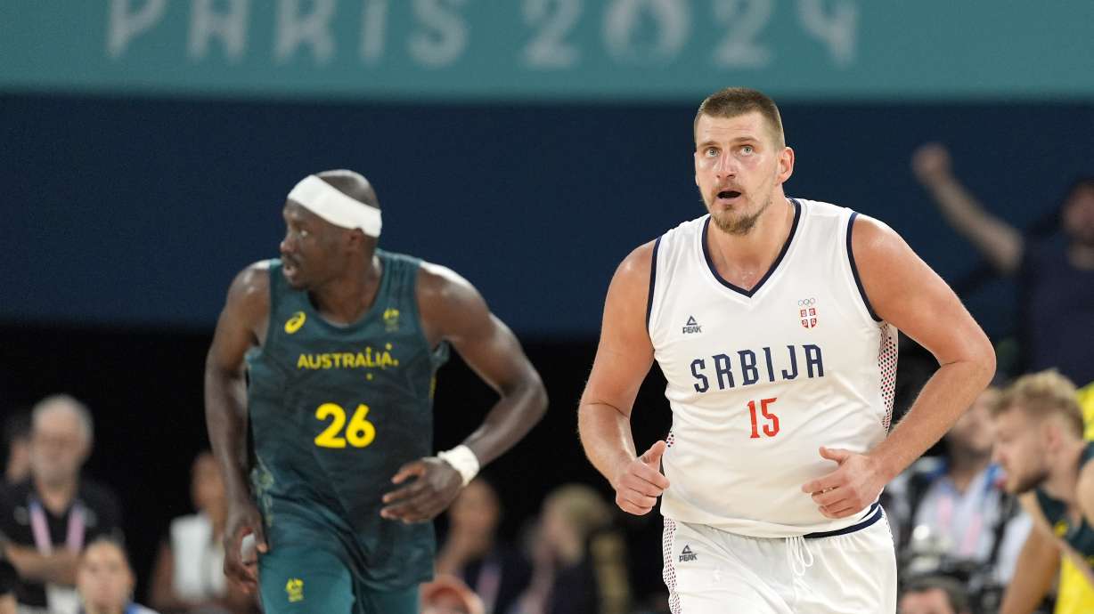 Serbia's Nikola Jokic, right, runs on the courts as Australia'a Duop Reath runs behind during a men's quarterfinal game at Bercy Arena at the 2024 Summer Olympics, Tuesday, Aug. 6, 2024, in Paris, France.