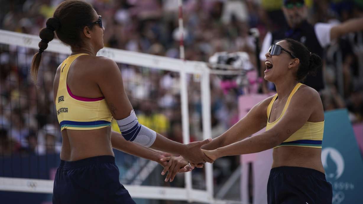Brazil's Eduarda Santos Lisboa, right, and Ana Patricia Silva Ramos celebrate during the women's quarterfinal beach volleyball match between Brazil and Latvia at Eiffel Tower Stadium at the 2024 Summer Olympics, Wednesday, Aug. 7, 2024, in Paris, France.
