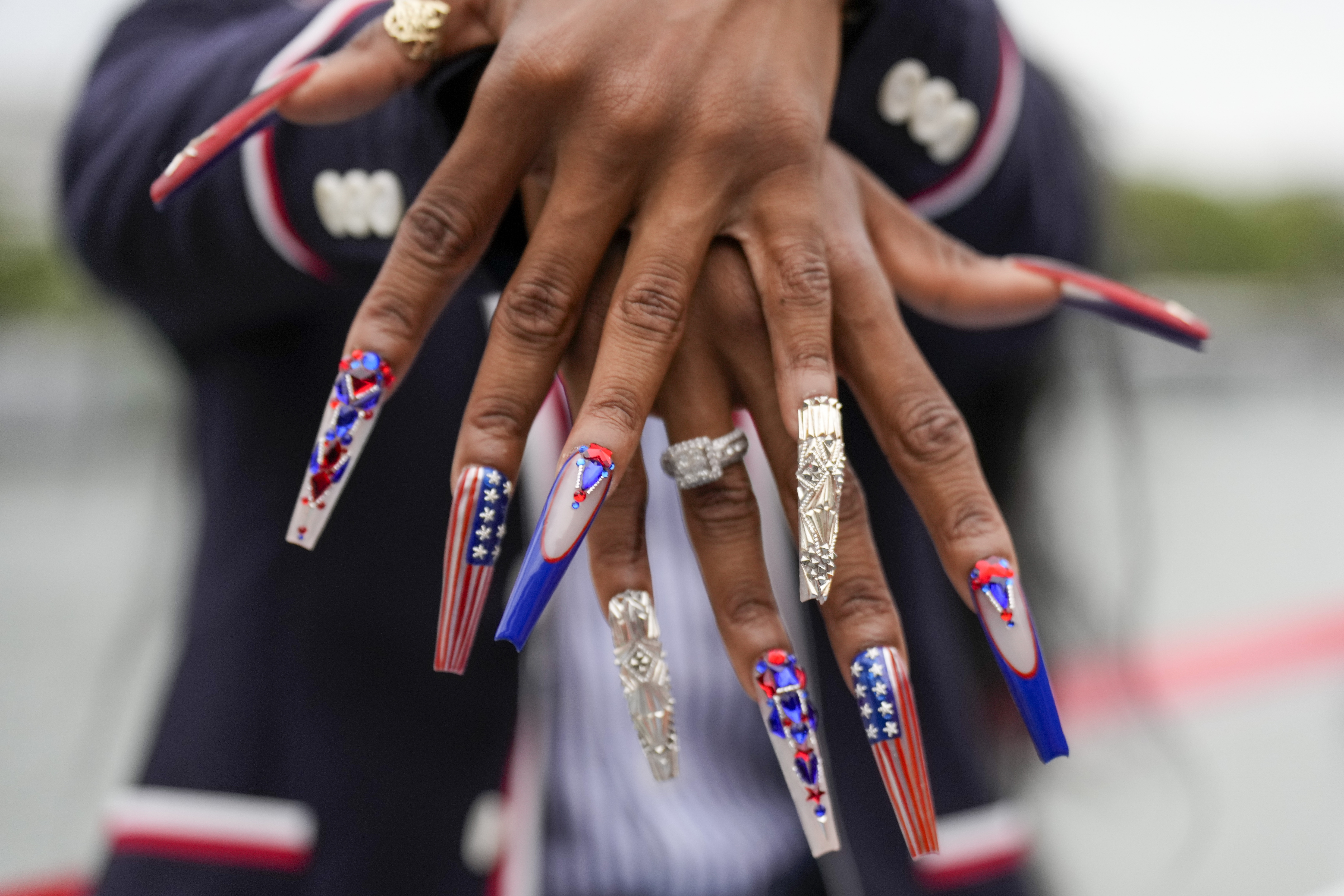 Sha'Carri Richardson, of the United States, shows off her nails while traveling along the Seine River in Paris, France, during the opening ceremony of the 2024 Summer Olympics, Friday, July 26, 2024. 