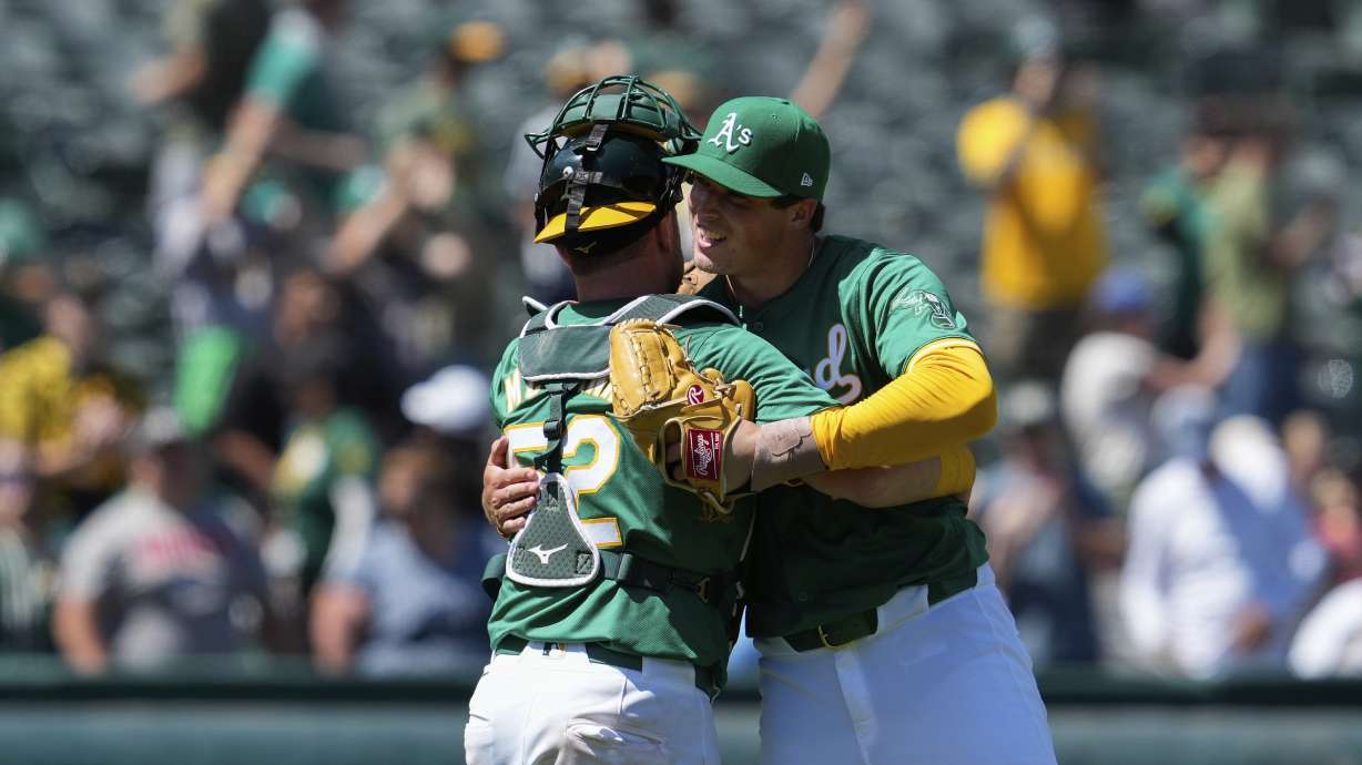 Oakland Athletics pitcher Mason Miller, right, celebrates with catcher Kyle McCann after the team's victory over the Chicago White Sox in a baseball game, Wednesday, Aug. 7, 2024, in Oakland, Calif.