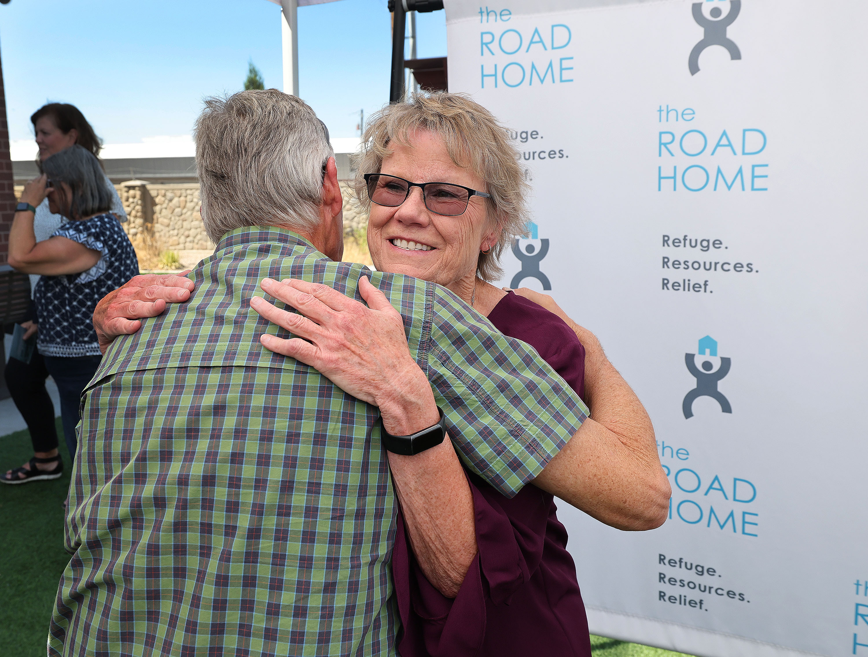 Connie Crosby is hugged by friend Lane Valum during the Road Home dedication for the Connie Crosby Midvale Family Resource Center that was named after her in Midvale on Wednesday.