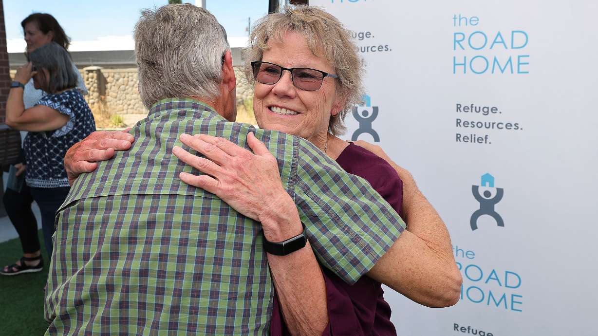 Connie Crosby is hugged by friend Lane Valum during the Road Home dedication for the Connie Crosby Midvale Family Resource Center that was named after her in Midvale on Wednesday.