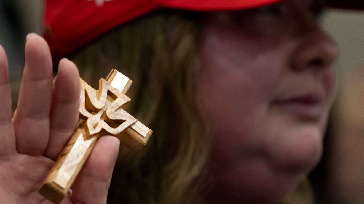Misty Grace of Green Bay, Wis., center, who describes herself as a follower of Jesus Christ, prays during a rally for former President Donald Trump at the KI Convention Center in Green Bay, Wis., on April 2. Trump is laying out his pitch to Christian voters.