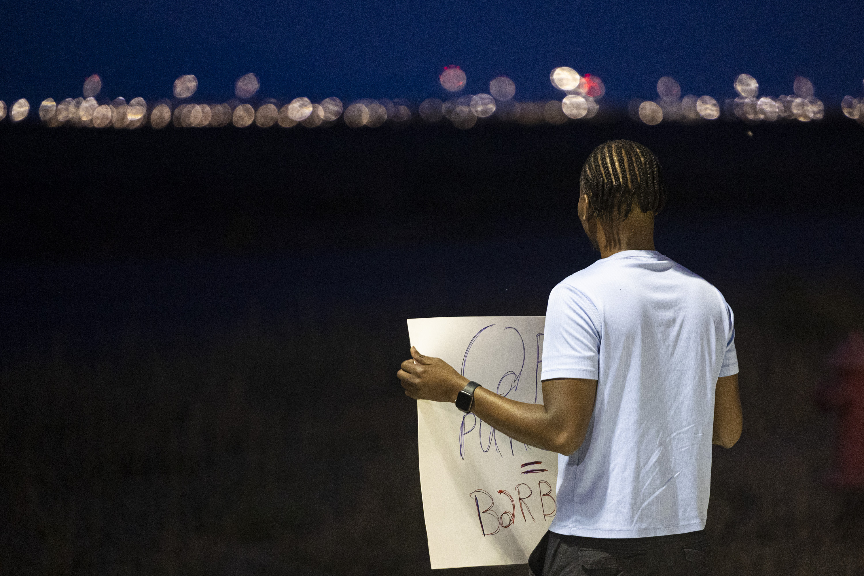Rony Charles, of Salt Lake City, holds a sign Wednesday as he looks in the direction of the Utah State Correctional Facility during a gathering held in a free speech zone established by the Utah Department of Corrections near the facility in Salt Lake City before the execution of Taberon Honie early Thursday.