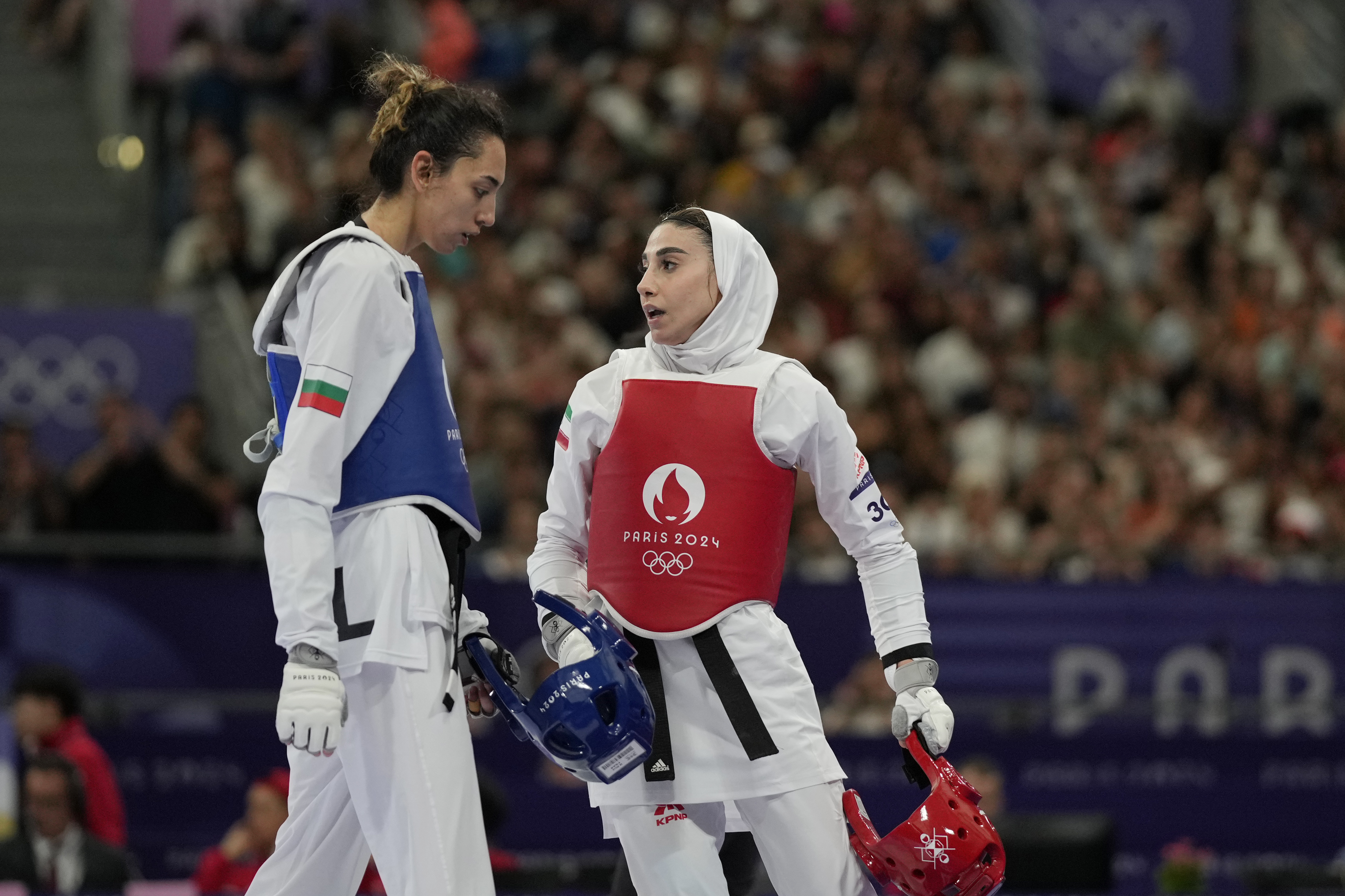Iran's Nahid Kiyanichandeh, right, reacts at the end of a women's 57kg Taekwondo match against Bulgaria's Kimia Alizadeh Zenozi during the 2024 Summer Olympics, at the Grand Palais, Thursday, Aug. 8, 2024, in Paris, France. 