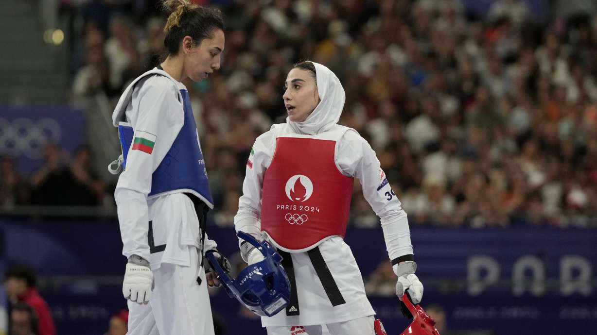 Iran's Nahid Kiyanichandeh, right, reacts at the end of a women's 57kg Taekwondo match against Bulgaria's Kimia Alizadeh Zenozi during the 2024 Summer Olympics, at the Grand Palais, Thursday, Aug. 8, 2024, in Paris, France.