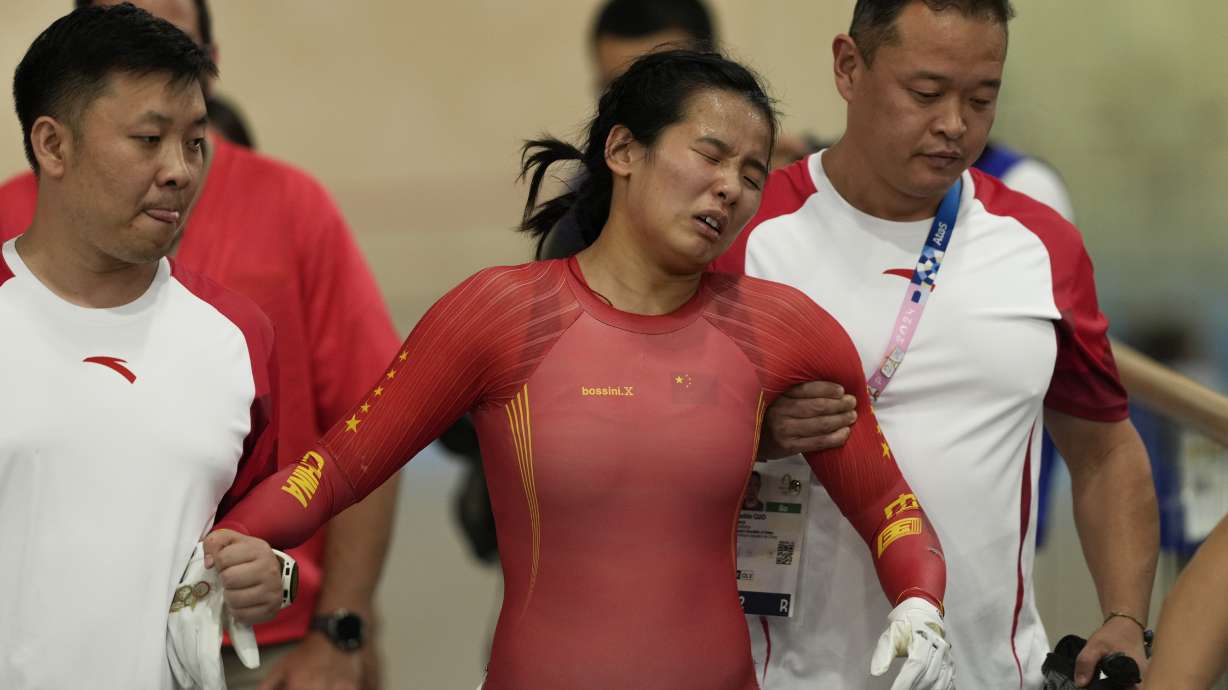 Liying Yuan of China is assisted after crashing during the women's keirin event, at the Summer Olympics, Thursday, Aug. 8, 2024, in Paris, France.