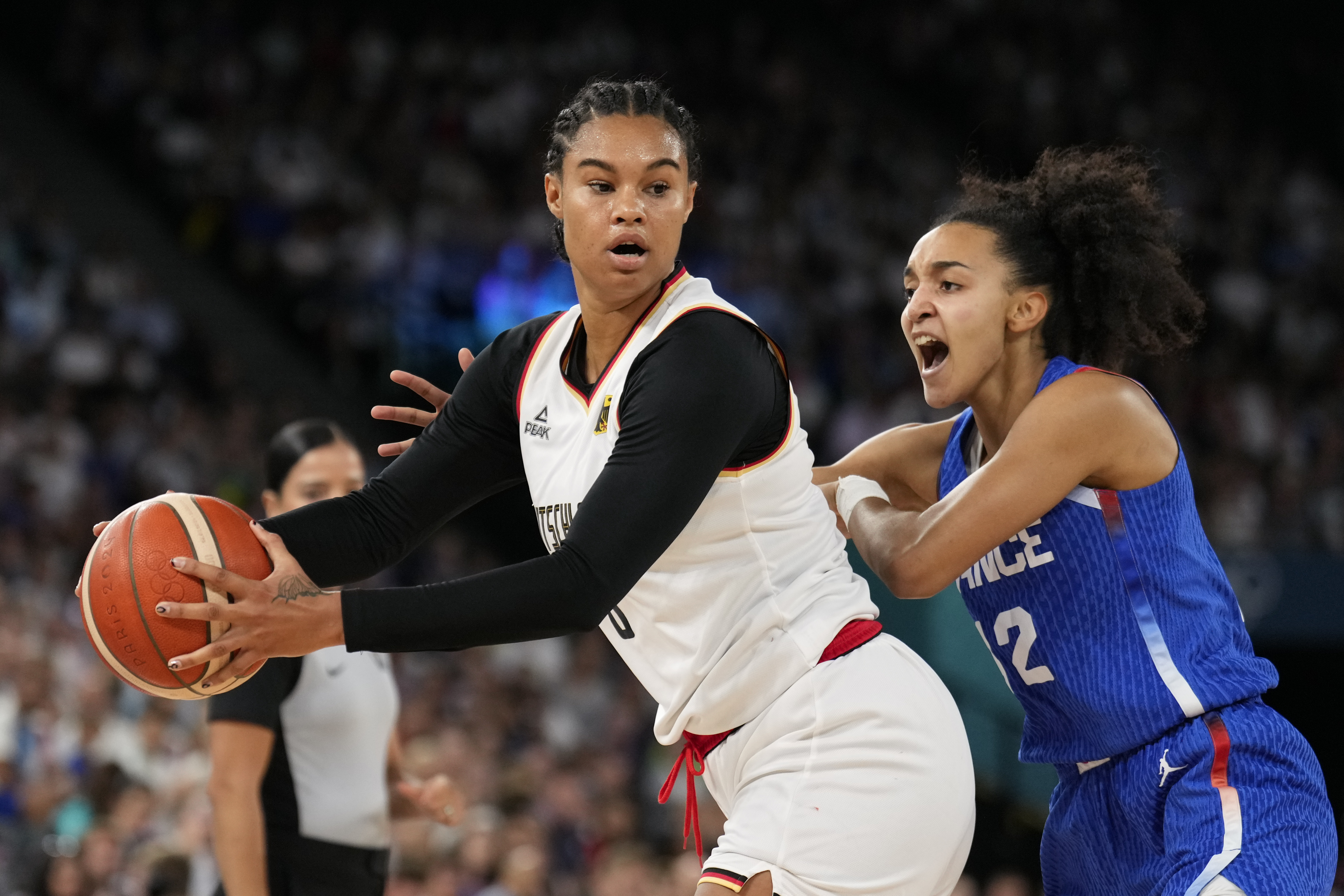 Iliana Rupert (12), of France, defends Satou Sabally (0), of Germany, during a women's quarterfinal game at Bercy Arena at the 2024 Summer Olympics, Wednesday, Aug. 7, 2024, in Paris, France. 