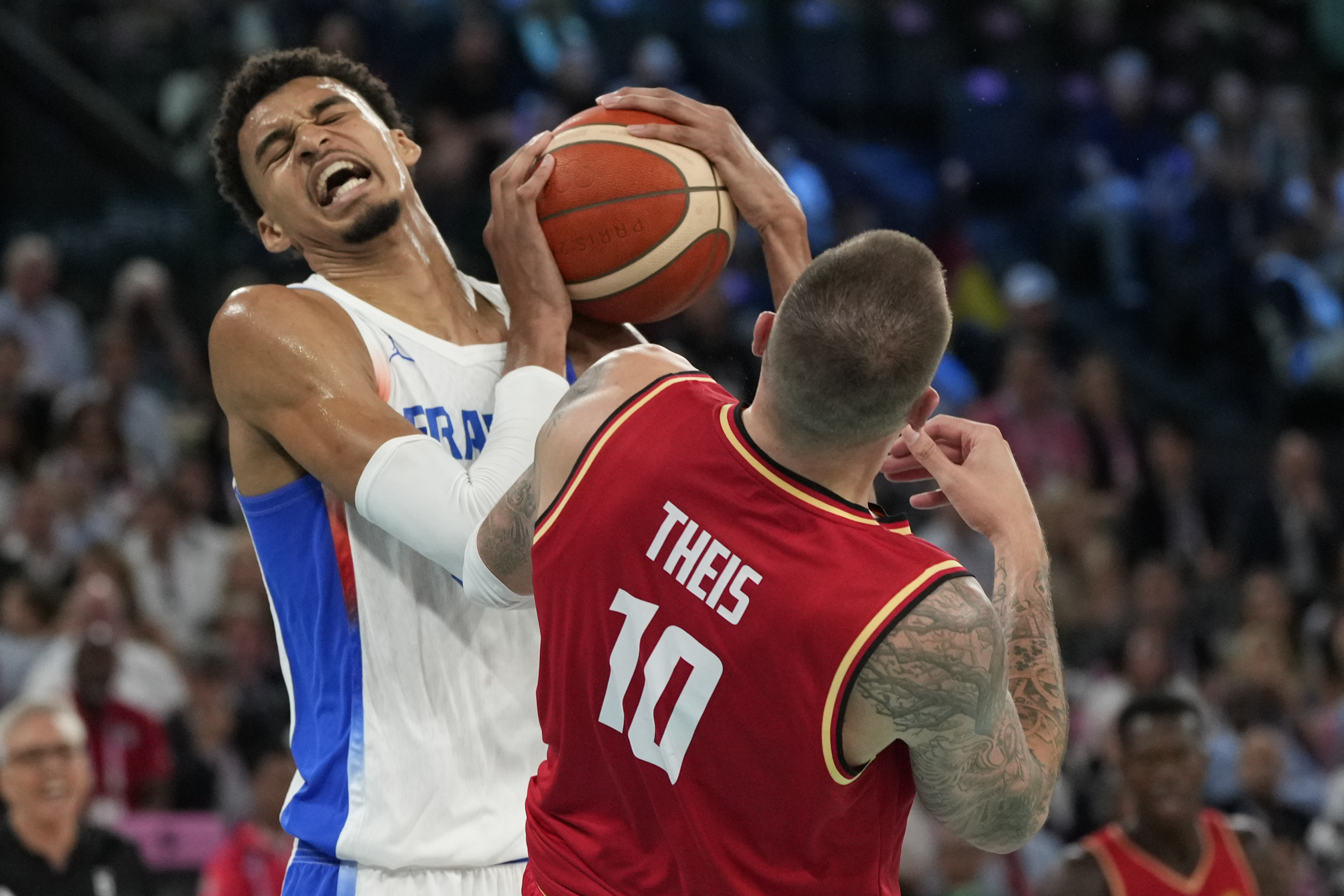 Victor Wembanyama (32), of France scrambles for possession against Daniel Theis (10), of Germany during a men's semifinals basketball game at Bercy Arena at the 2024 Summer Olympics, Thursday, Aug. 8, 2024, in Paris, France. 
