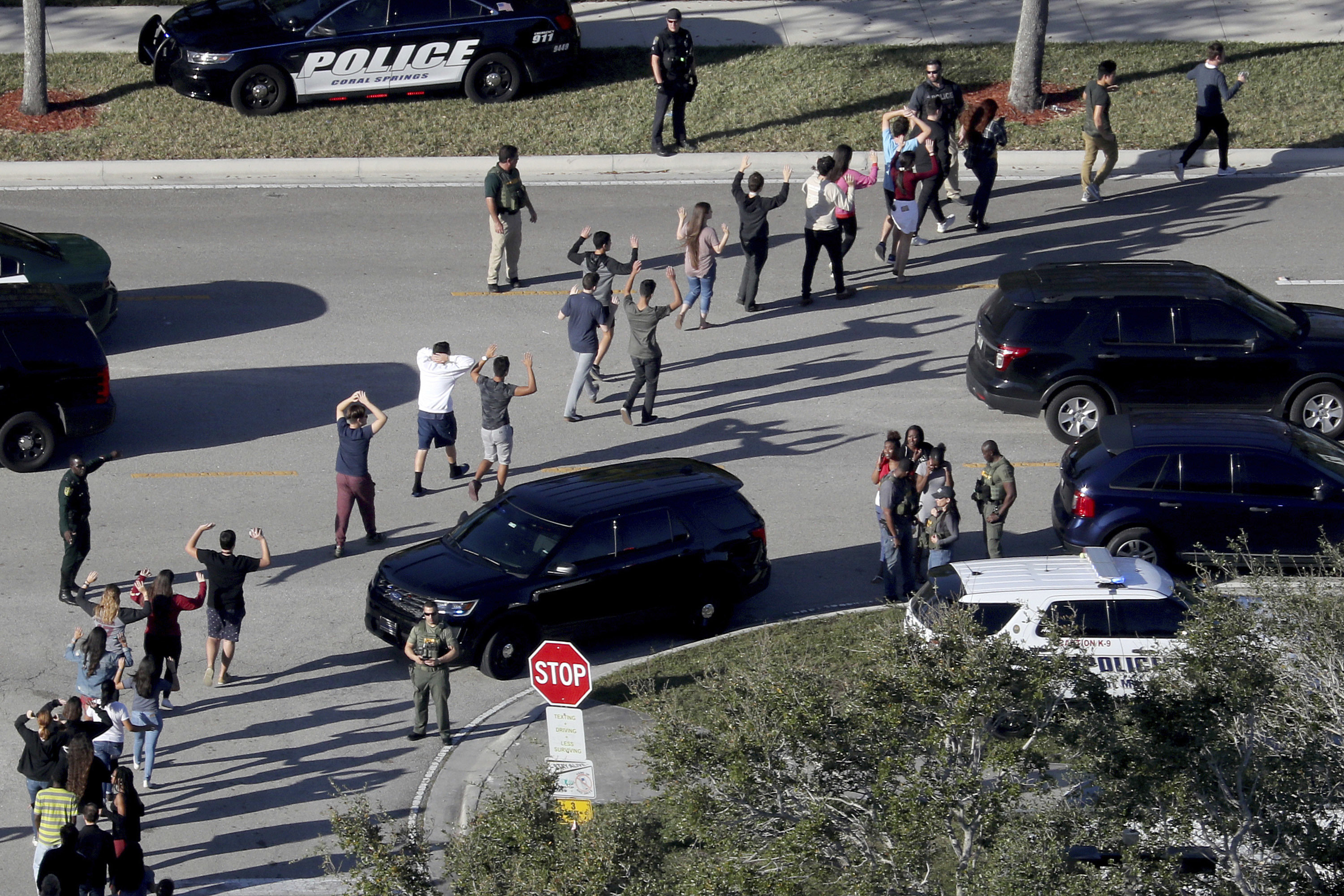 Students evacuate Marjory Stoneman Douglas High School in Parkland, Fla., after a shooter opened fire on the campus on Feb. 14, 2018. Families of three students murdered in the shooting have reached multimillion-dollar settlements in a lawsuit against the shooter.