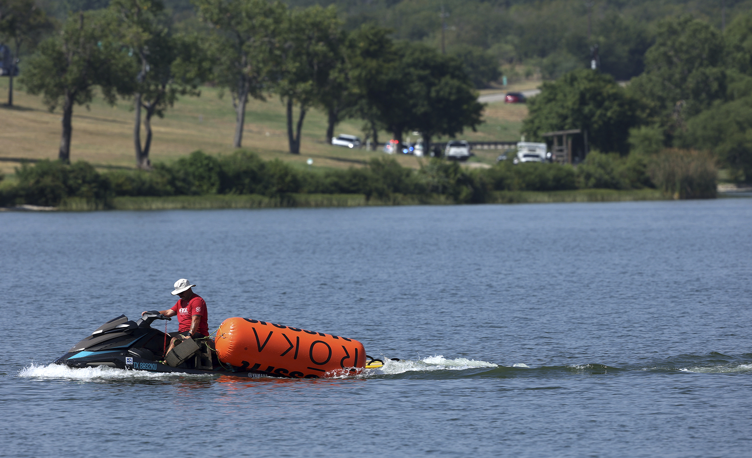 A jet ski pulls in buoys from the CrossFit Games at Marine Creek Lake, where an athlete drowned during the run swim event on Thursday, Aug. 8, 2024 in Fort Worth, Texas,