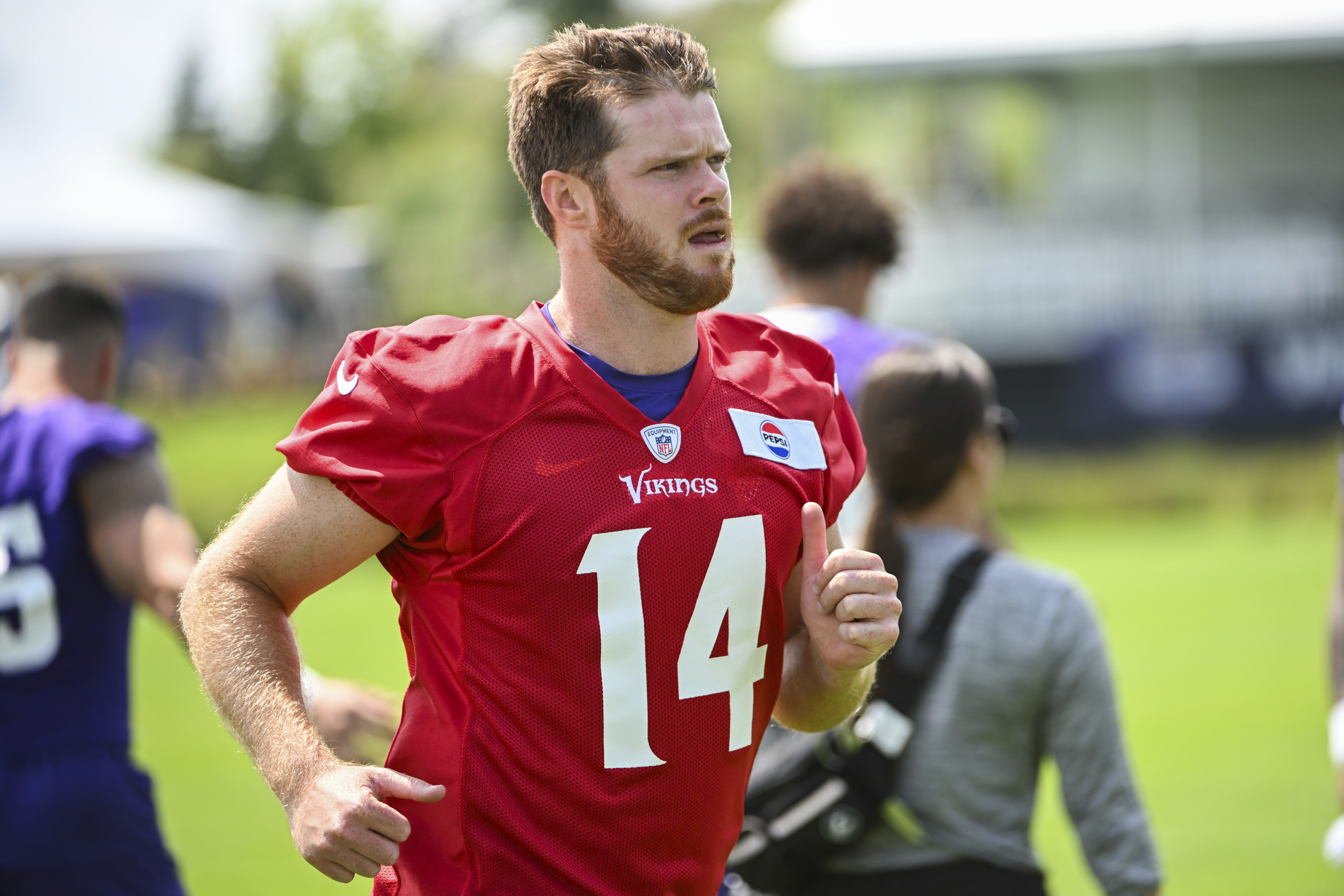 Minnesota Vikings quarter back Sam Darnold jogs on to the field during NFL football training camp in Eagan, Minn., Wednesday, July 24, 2024.
