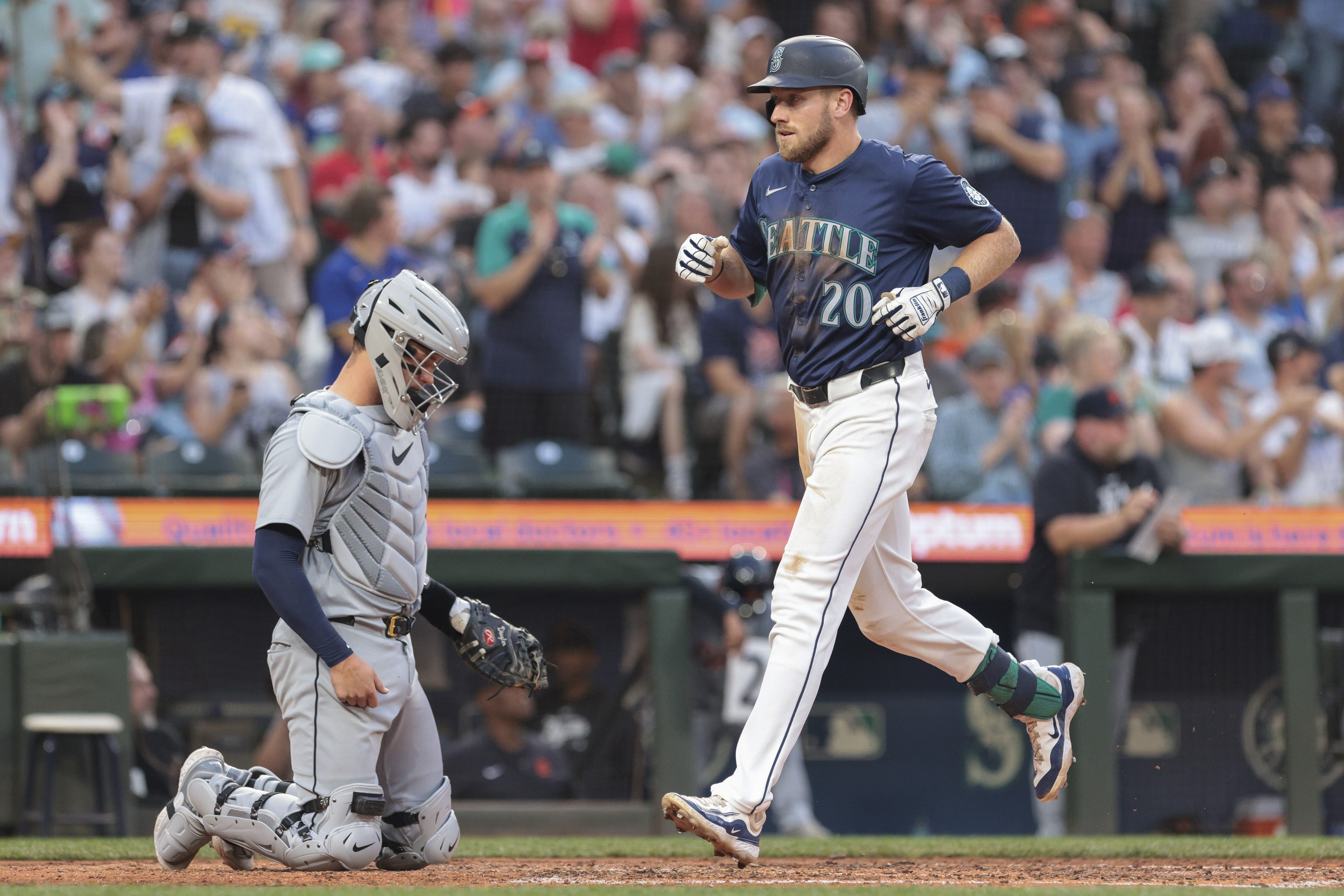 Seattle Mariners' Luke Raley (20) crosses home after hitting a home run as Detroit Tigers catcher Dillon Dingler, left, looks on during the sixth inning of a baseball game, Thursday, Aug. 8, 2024, in Seattle. 