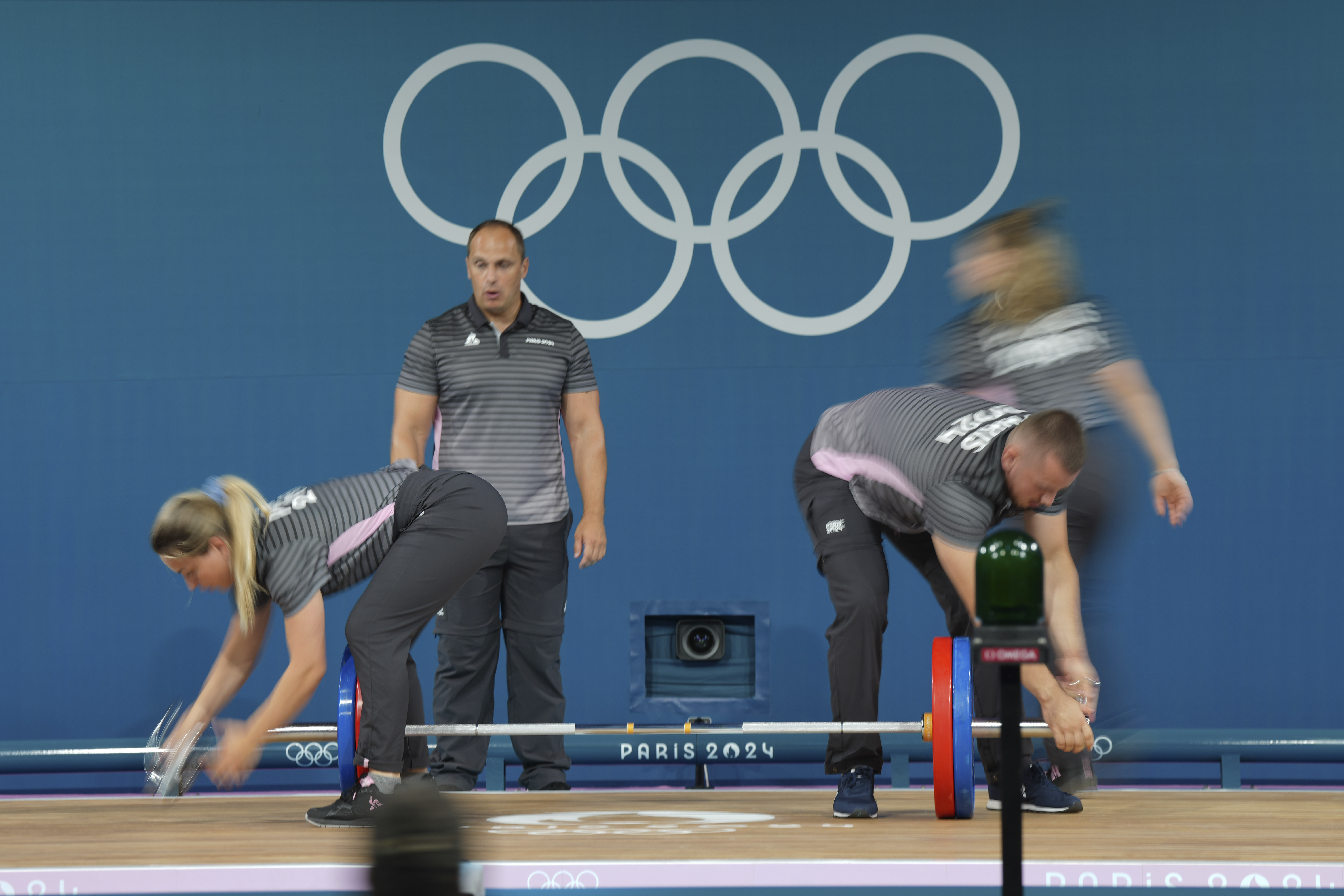 Loaders set the weight on the bar during the women's 59kg weightlifting event at the 2024 Summer Olympics, Thursday, Aug. 8, 2024, in Paris, France. 