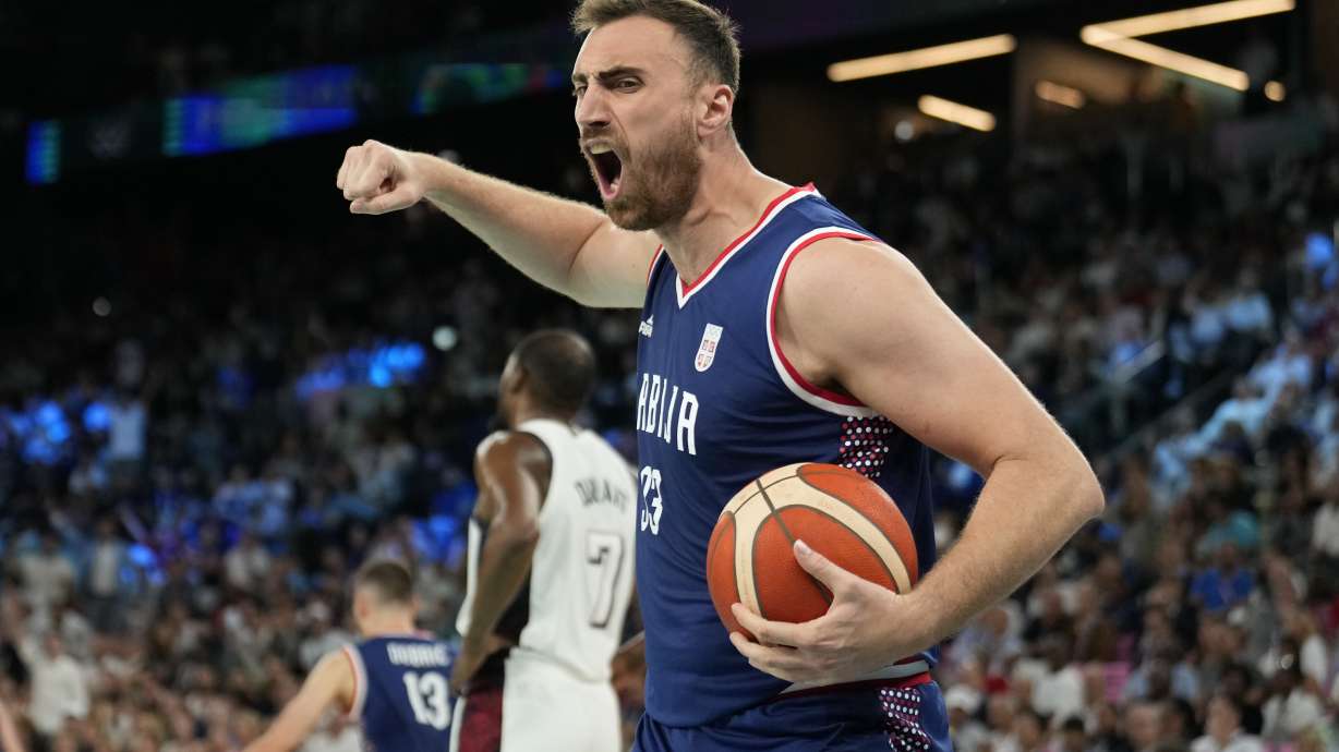 Nikola Milutinov (33), of Serbia celebrates after Marko Guduric (23), of Serbia scored and drew a foul against the United States during a men's semifinals basketball game at Bercy Arena at the 2024 Summer Olympics, Thursday, Aug. 8, 2024, in Paris, France.