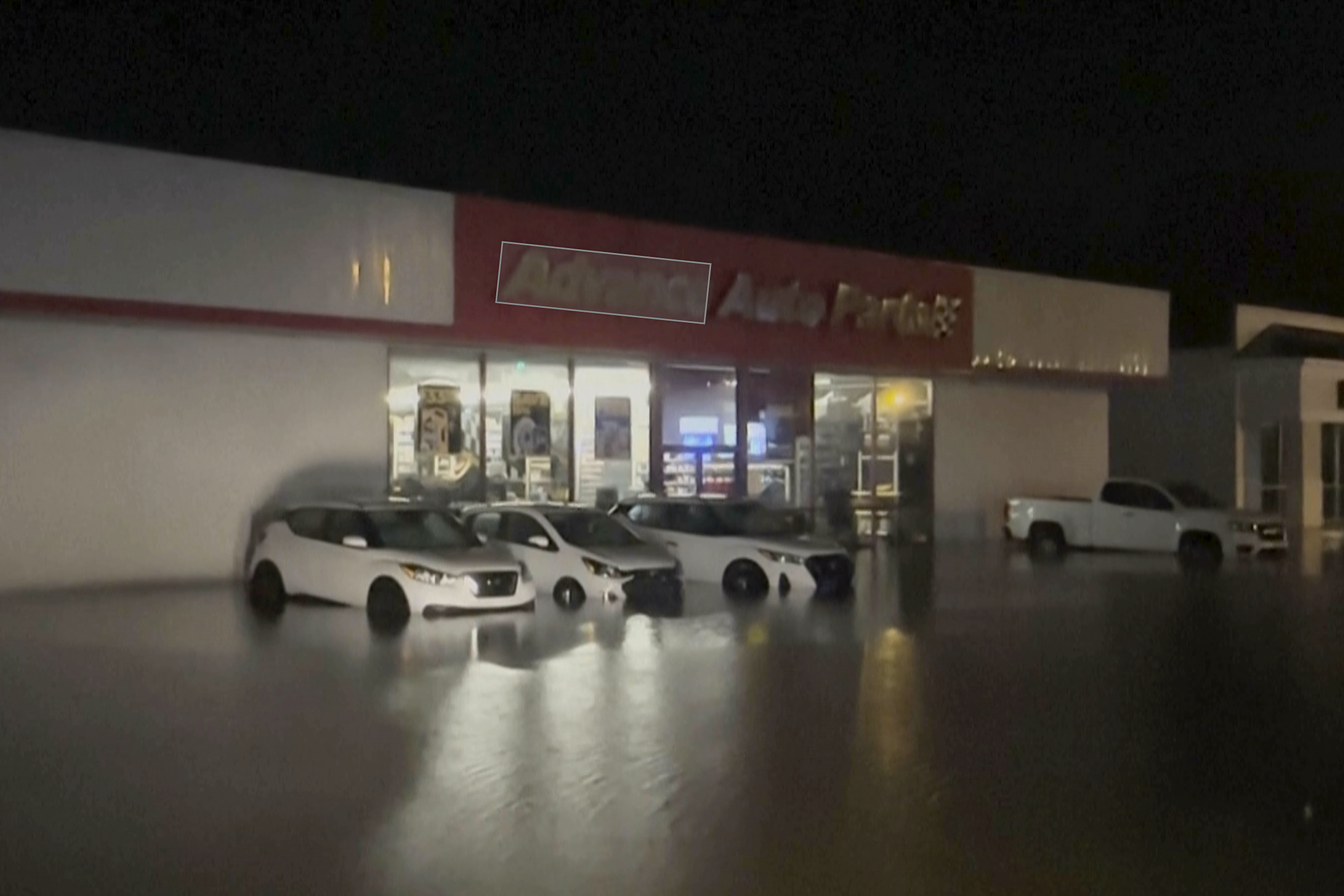 Flash floods surround cars parked outside a store in Moncks Corner, S.C., following Tropical Storm Debby, on Friday.