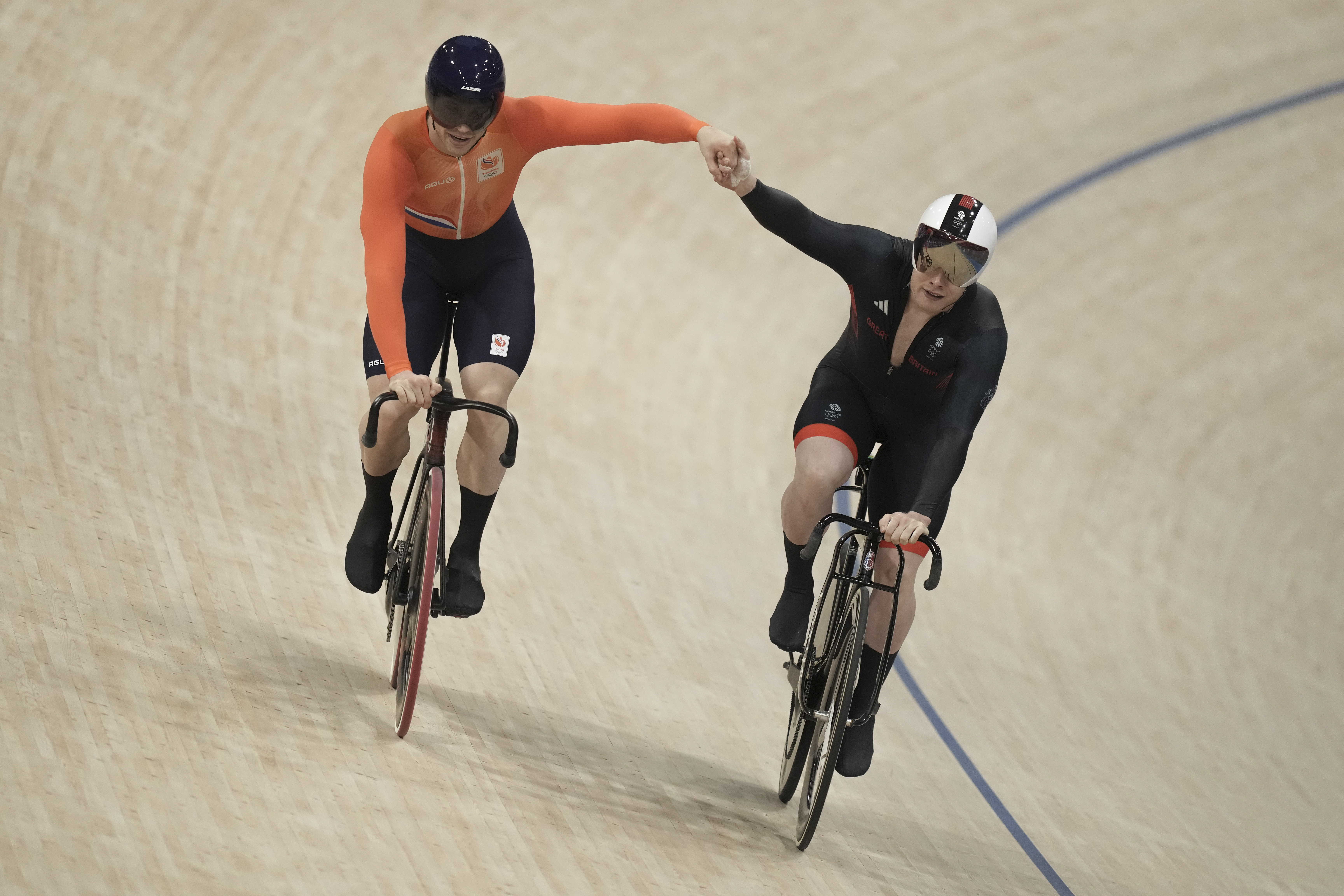 Harrie Lavreysen of Netherlands, left, and Jack Carlin of Britain greet each other as they compete during the men's sprint semifinals, at the Summer Olympics, Friday, Aug. 9, 2024, in Paris, France. 