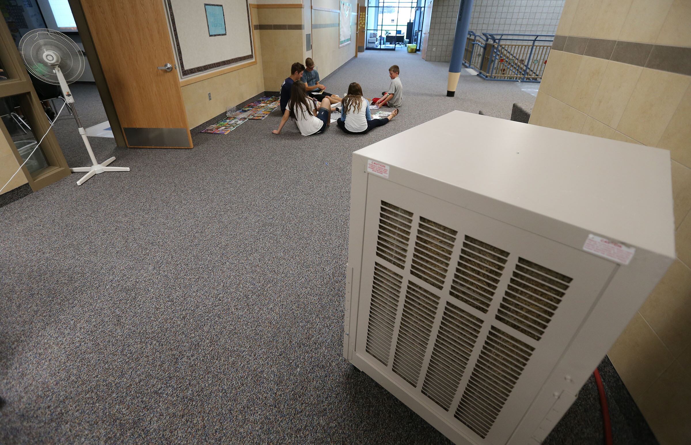 Kids are pictured working in a hallway on July 28, 2014, at Blackridge Elementary in Herriman while the new school's air conditioning wasn't online yet. The ideal temperature for a classroom to maximize students’ ability to learn reading and math is 68-74 degrees Farenheit, according to Pennsylvania State University.
