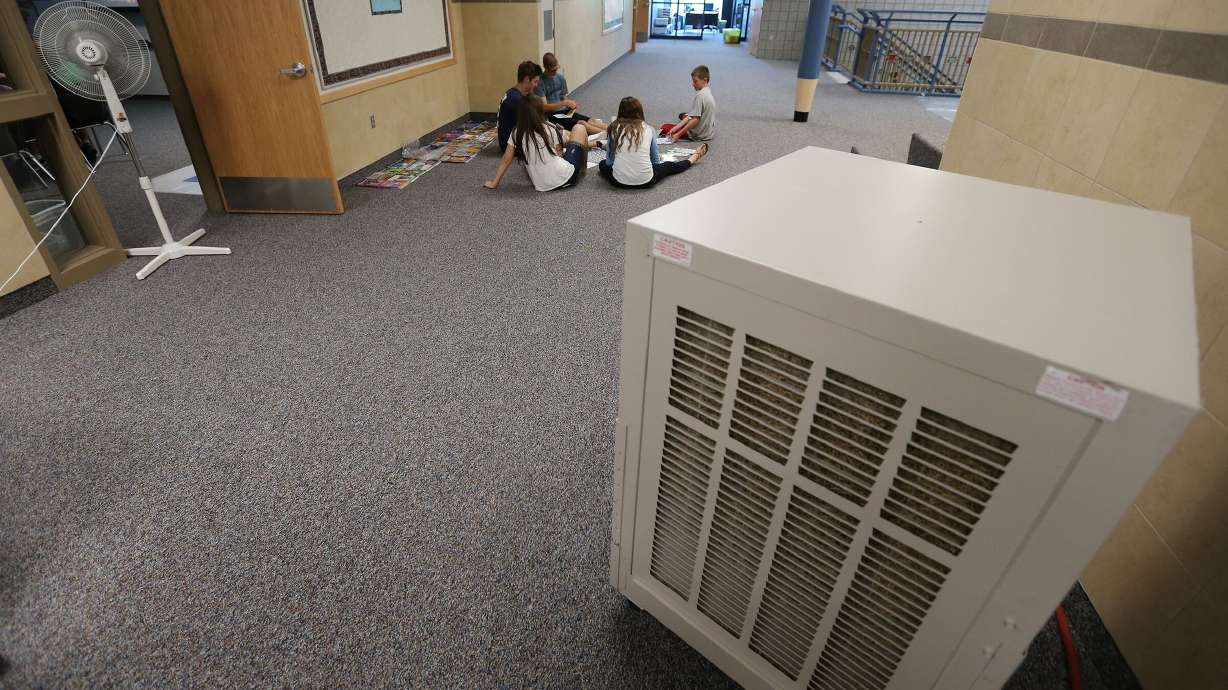 Kids are pictured working in a hallway on July 28, 2014, at Blackridge Elementary in Herriman while the new school's air conditioning wasn't online yet. The ideal temperature for a classroom to maximize students’ ability to learn reading and math is 68-74 degrees Farenheit, according to Pennsylvania State University.