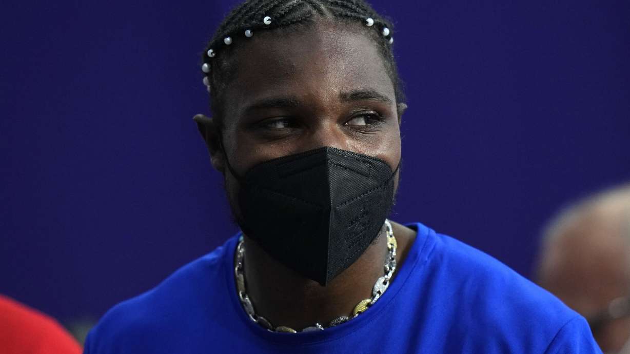 Noah Lyles, of the United States, dons a face mask following his men's 200-meters final at the 2024 Summer Olympics, Thursday, Aug. 8, 2024, in Saint-Denis, France.