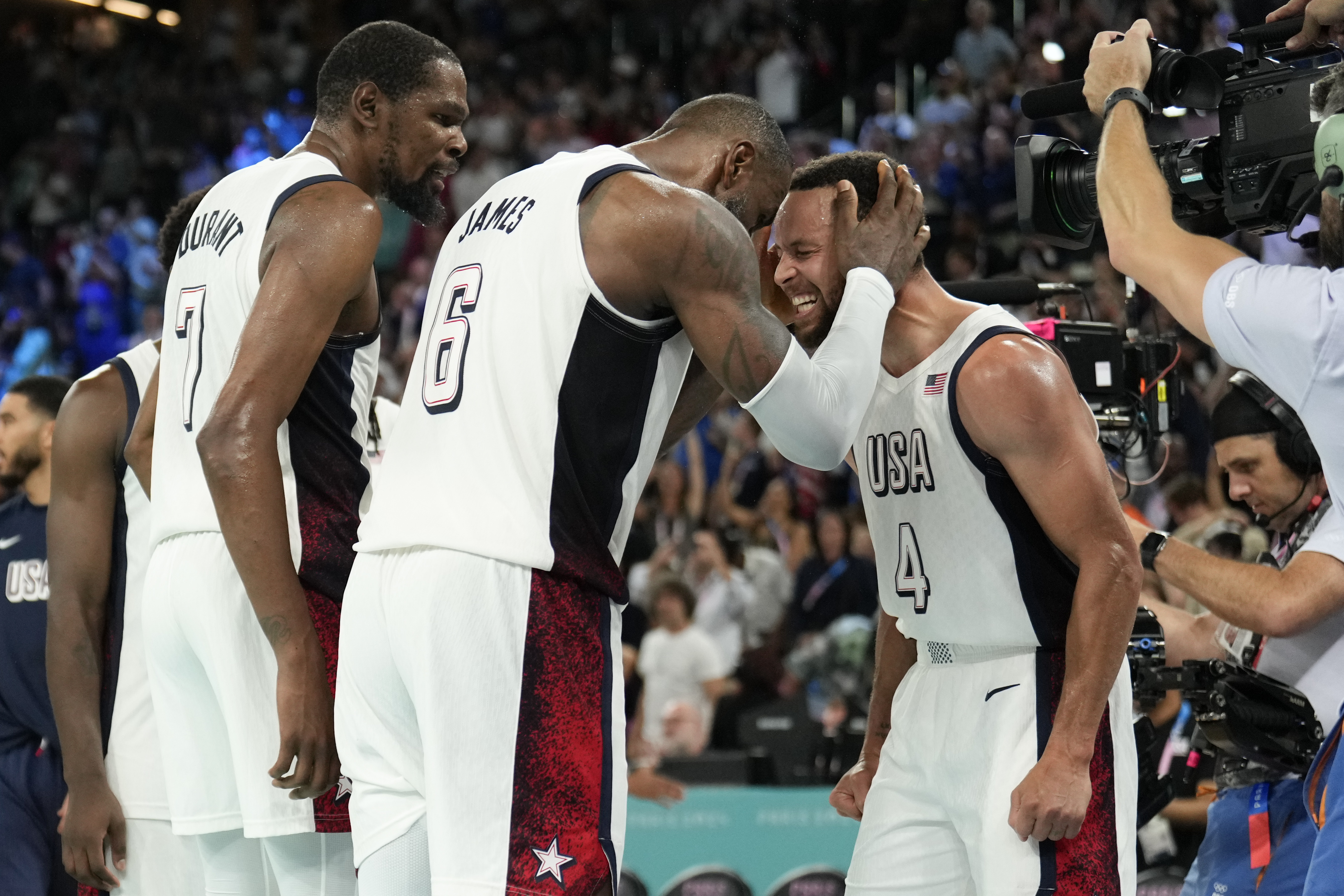 United States' Kevin Durant (7), LeBron James (6) and Steph Curry (4) celebrate after beating Serbia during a men's semifinals basketball game at Bercy Arena at the 2024 Summer Olympics, Thursday, Aug. 8, 2024, in Paris, France. 