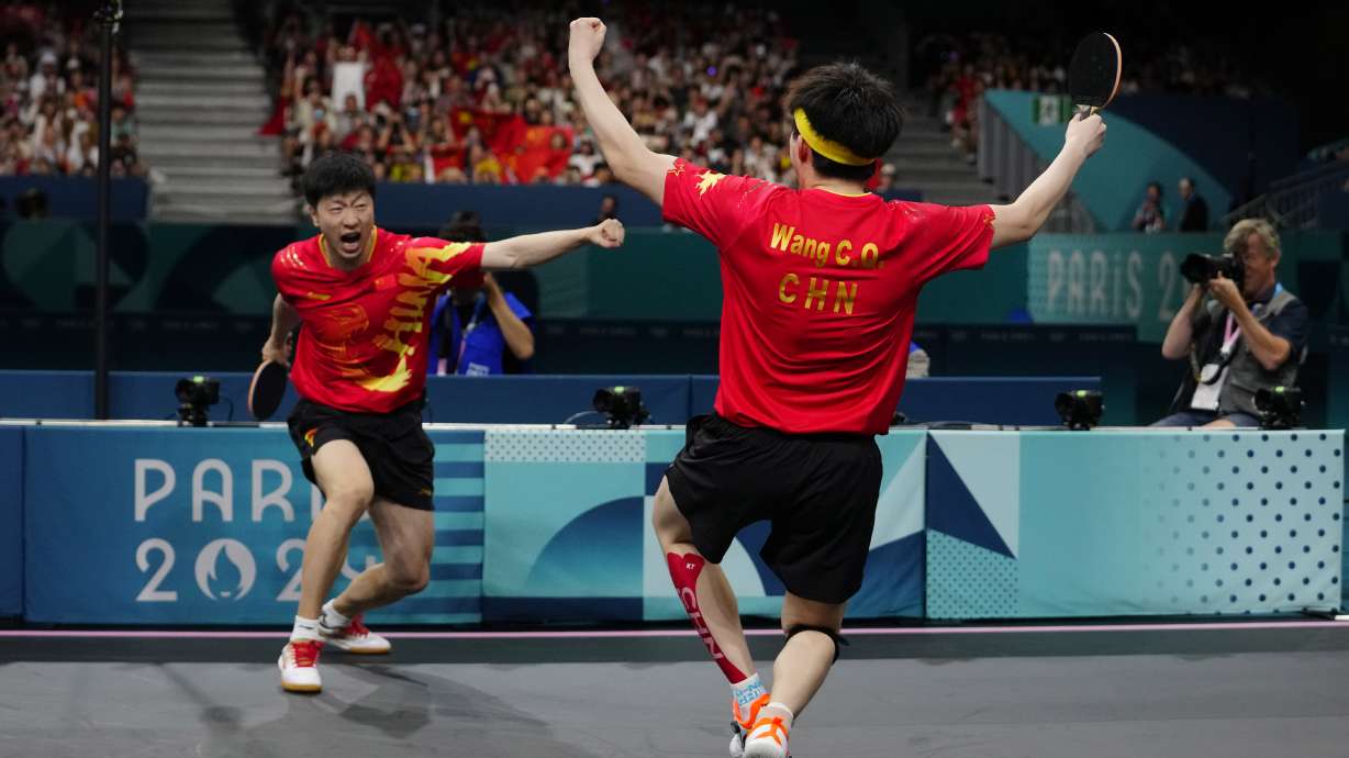 China's Ma Long, background, and Wang Chuqin celebrate after defeating Sweden's Anton Kallberg and Kristian Karlsson during the men's gold medal team table tennis match at the 2024 Summer Olympics, Friday, Aug. 9, 2024, in Paris, France.