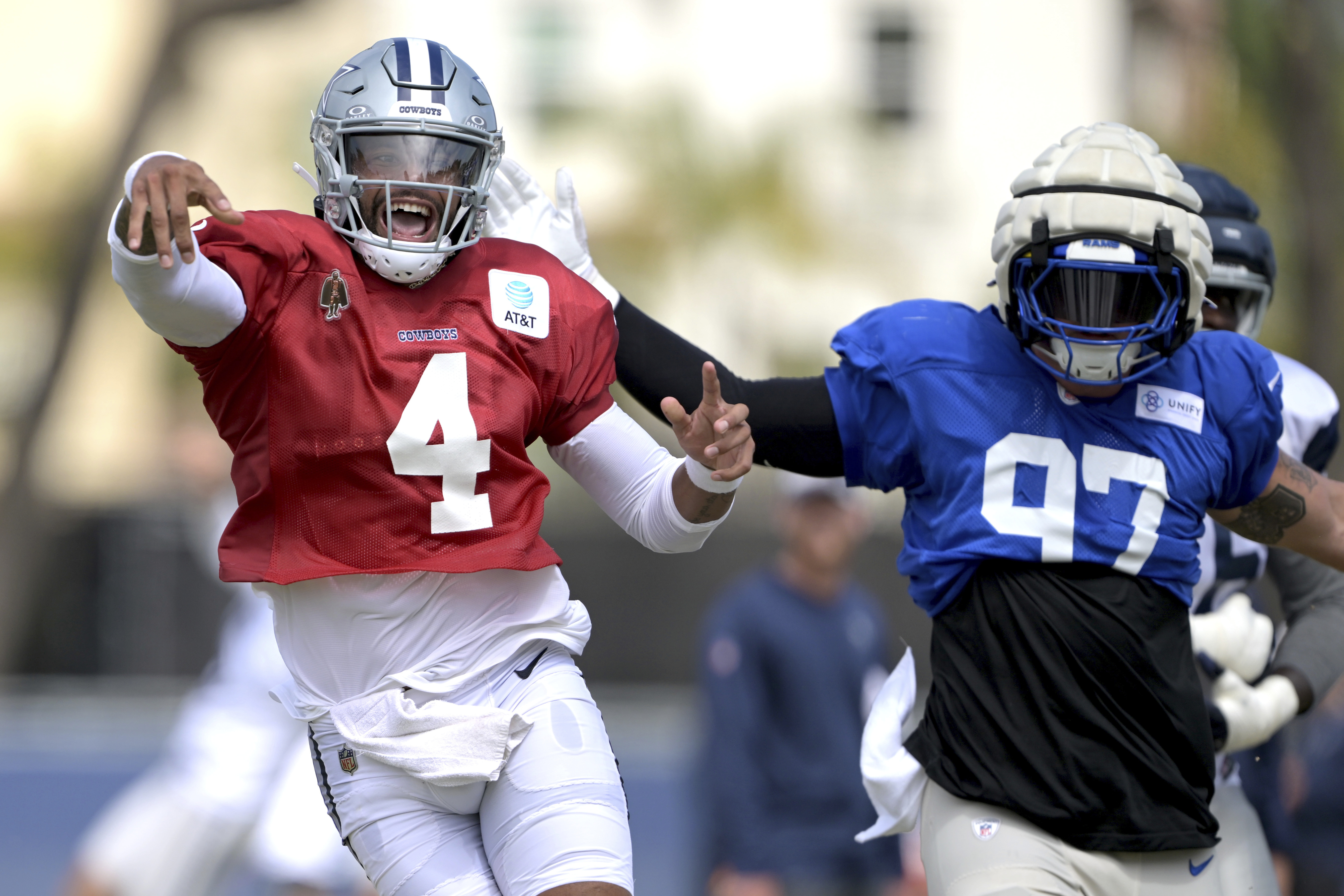 Dallas Cowboys quarterback Dak Prescott (4) looks for an open receiver as he is defended by Los Angeles Rams linebacker Michael Hoech during a joint practice at the Cowboy's NFL football training camp Thursday, Aug. 8, 2024, in Oxnard, Calif.