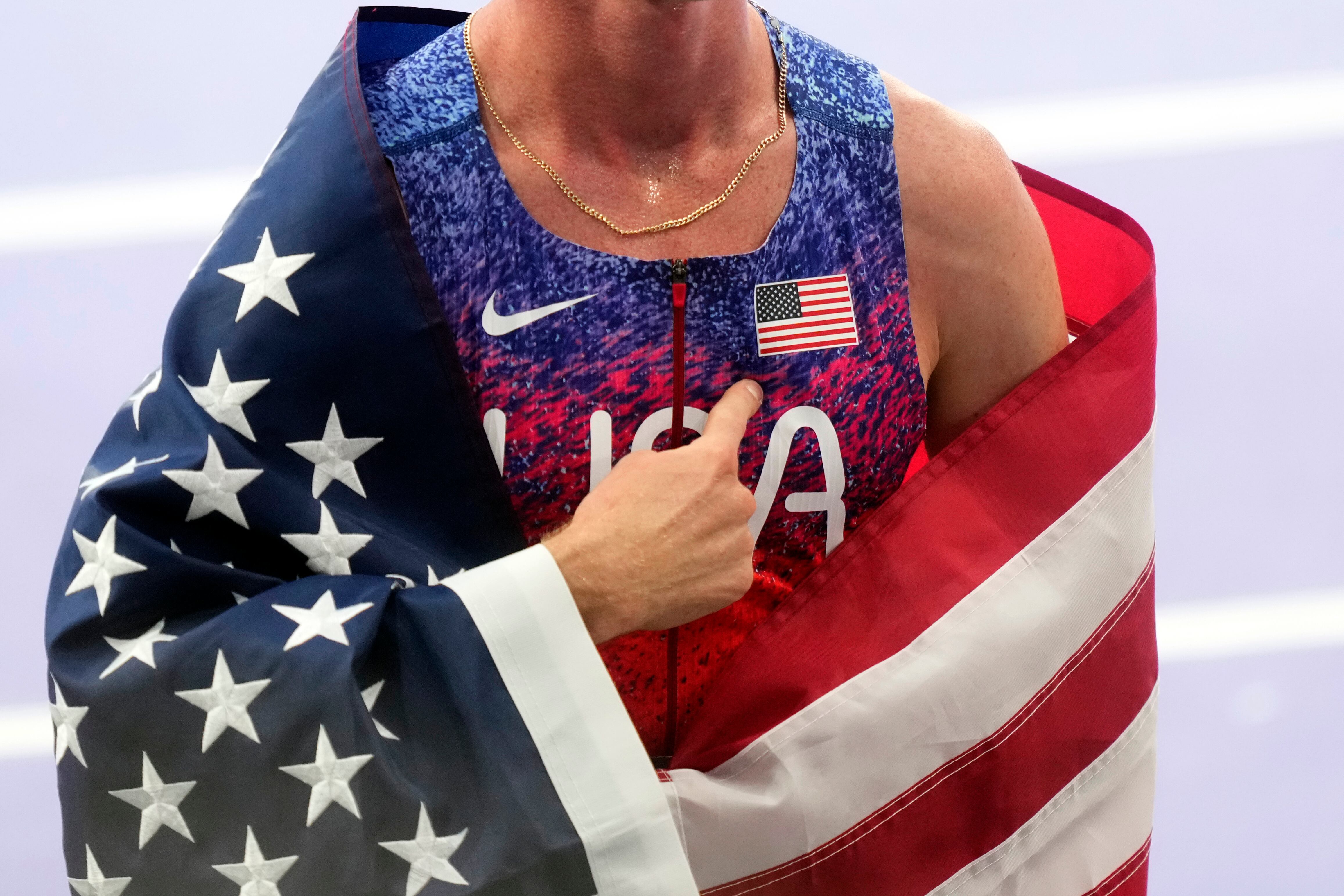 Cole Hocker of the United States points to an American flag patch on his chest after winning the gold medal in the men's 1500 meters final at the 2024 Summer Olympics, Tuesday in Saint-Denis, France.