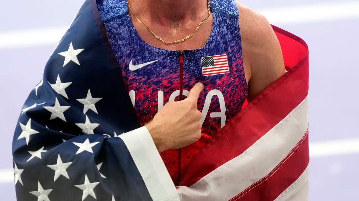 Cole Hocker of the United States points to an American flag patch on his chest after winning the gold medal in the men's 1500 meters final at the 2024 Summer Olympics, Tuesday in Saint-Denis, France.