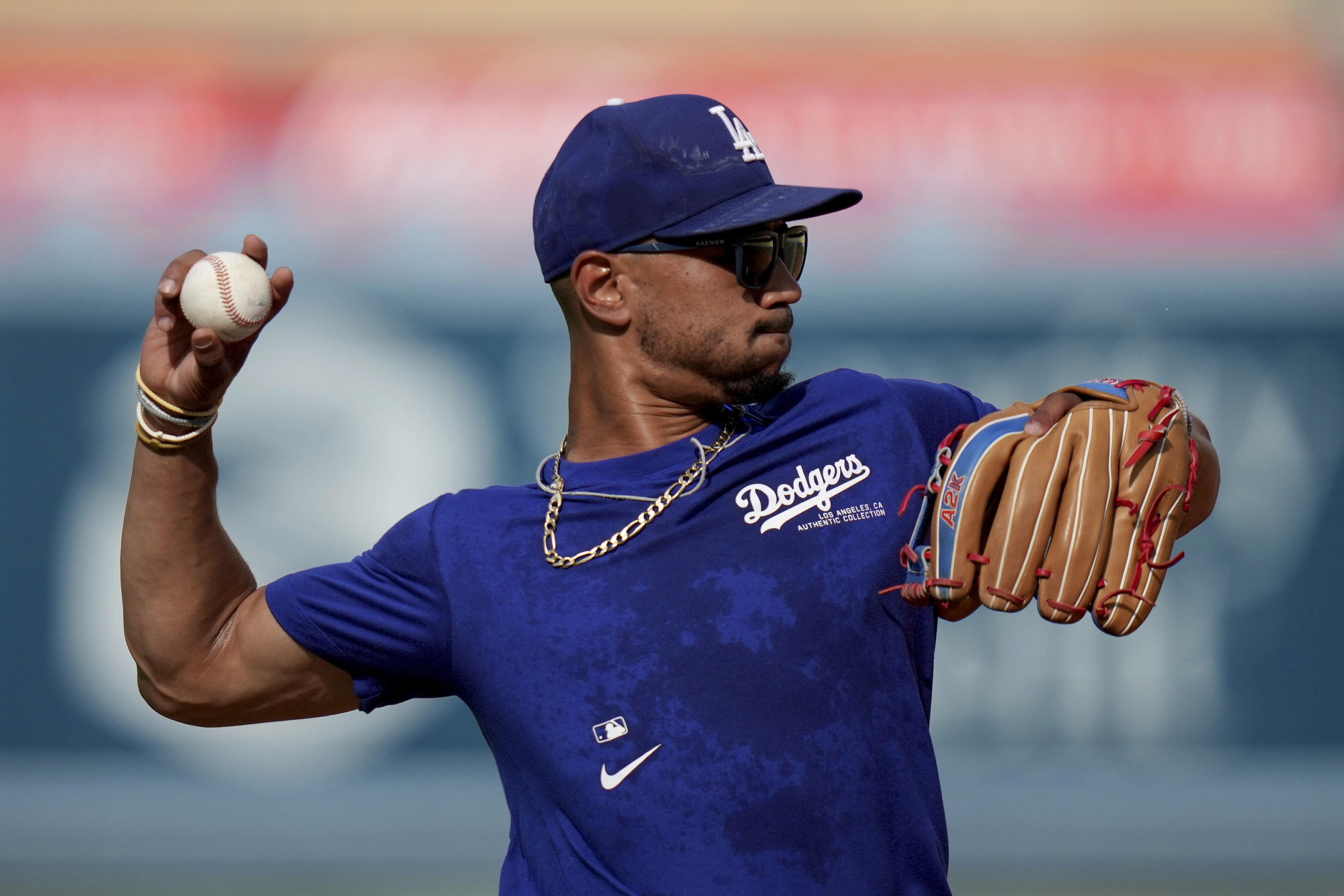 Los Angeles Dodgers' Mookie Betts throws during warm ups before a baseball game against Philadelphia Phillies in Los Angeles, Wednesday, Aug. 7, 2024. 