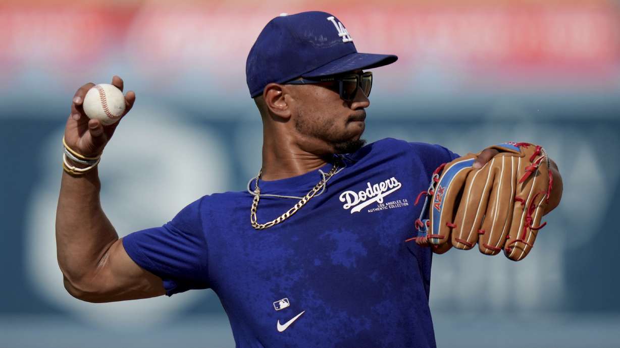 Los Angeles Dodgers' Mookie Betts throws during warm ups before a baseball game against Philadelphia Phillies in Los Angeles, Wednesday, Aug. 7, 2024.