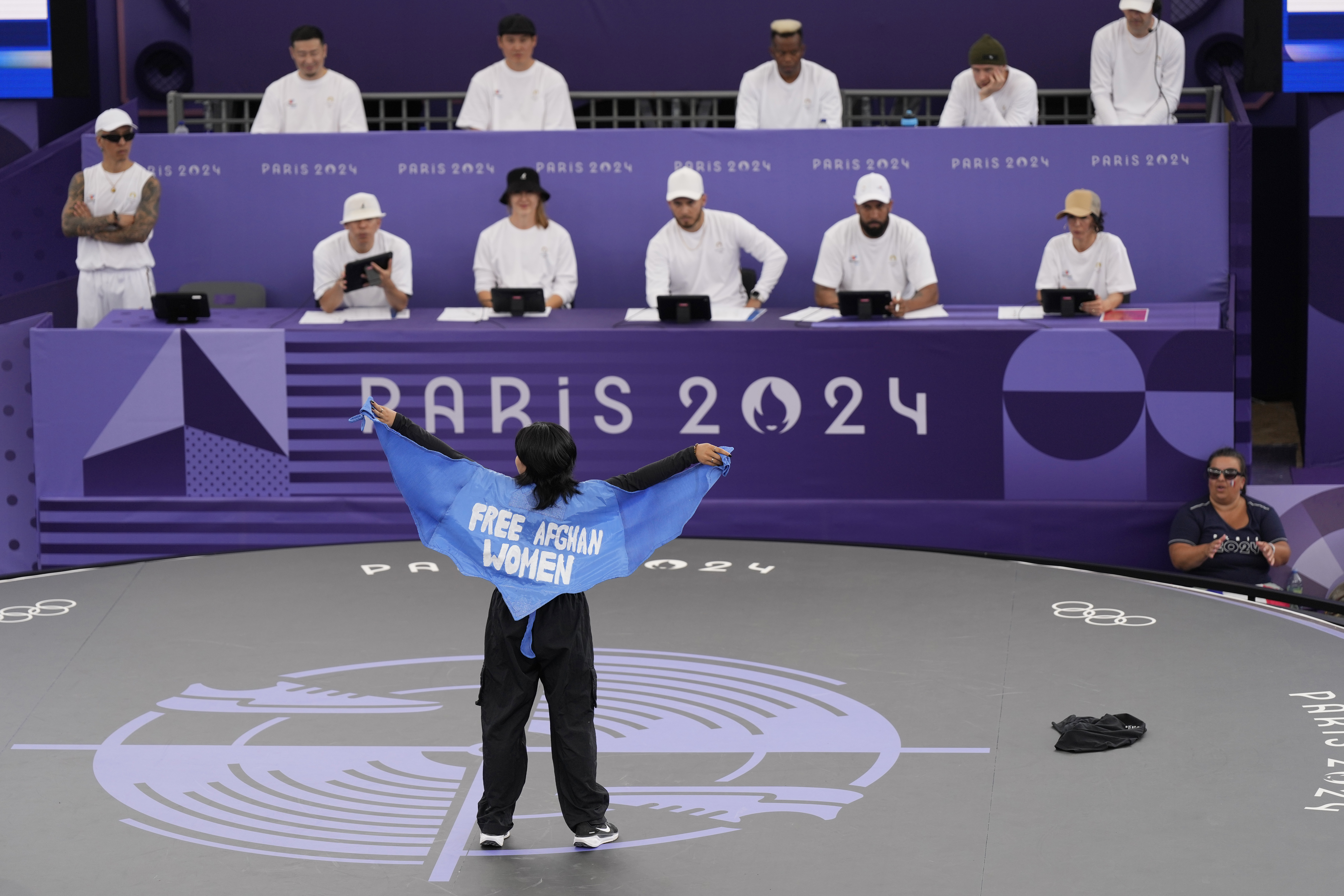 Refugee Team's Manizha Talash, known as Talash, wears a cape which reads "free Afghan women" as she competes during the B-Girls Pre-Qualifier Battle at the breaking competition at La Concorde Urban Park at the 2024 Summer Olympics, Friday, Aug. 9, 2024, in Paris, France. 