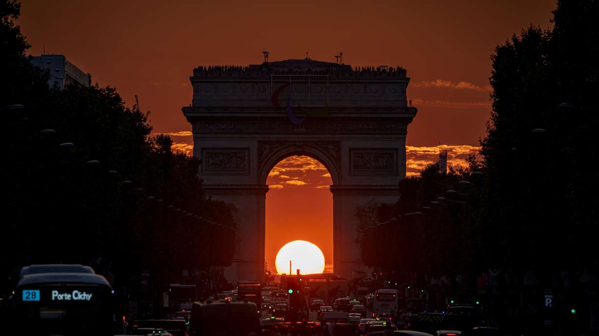 The setting sun, framed by the Arc de Triomphe, illuminates the Champs-Élysées during the 2024 Summer Olympics, Friday, Aug. 2, 2024, in Paris, France.