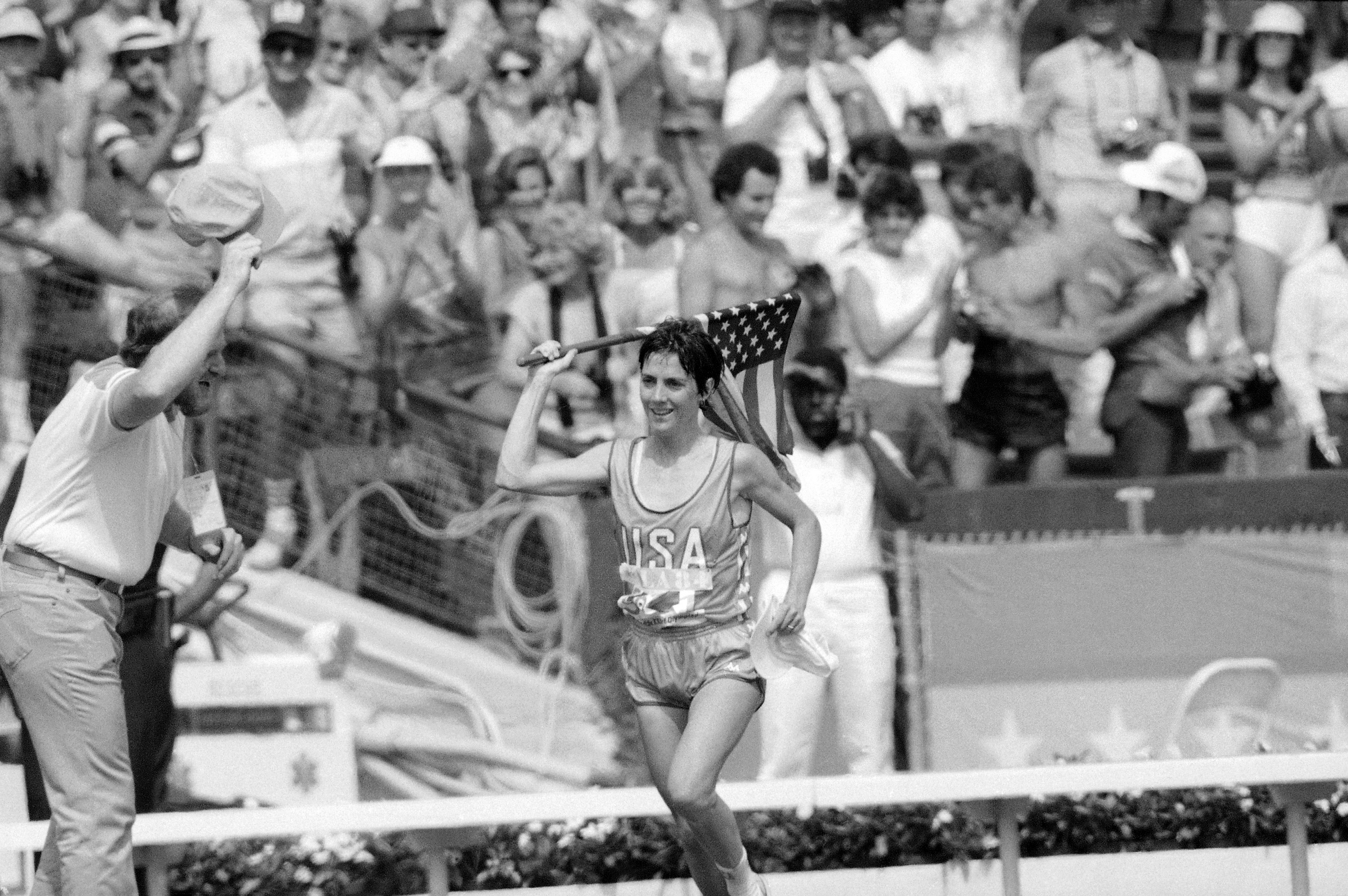 FILE - Twenty-seven-year-old Joan Benoit of Freeport, Maine, waves the American flag enthusiastically on Aug. 5, 1984, in Los Angeles after finishing the first-ever Olympic women's marathon in the fastest-ever time for that distance. 2.24:52 for the 26-mile, 385-yard course. 