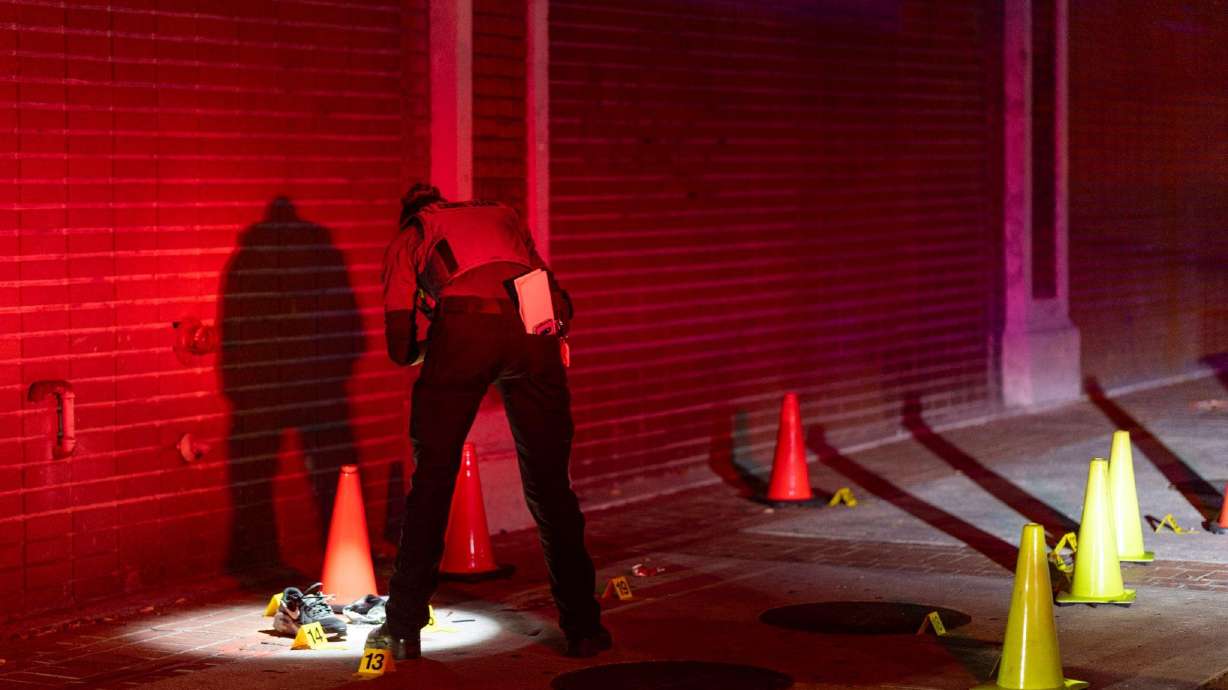 A Salt Lake City Police Crime Lab technician takes photos of evidence found on scene of a shooting near 355 S. State Street on Saturday.