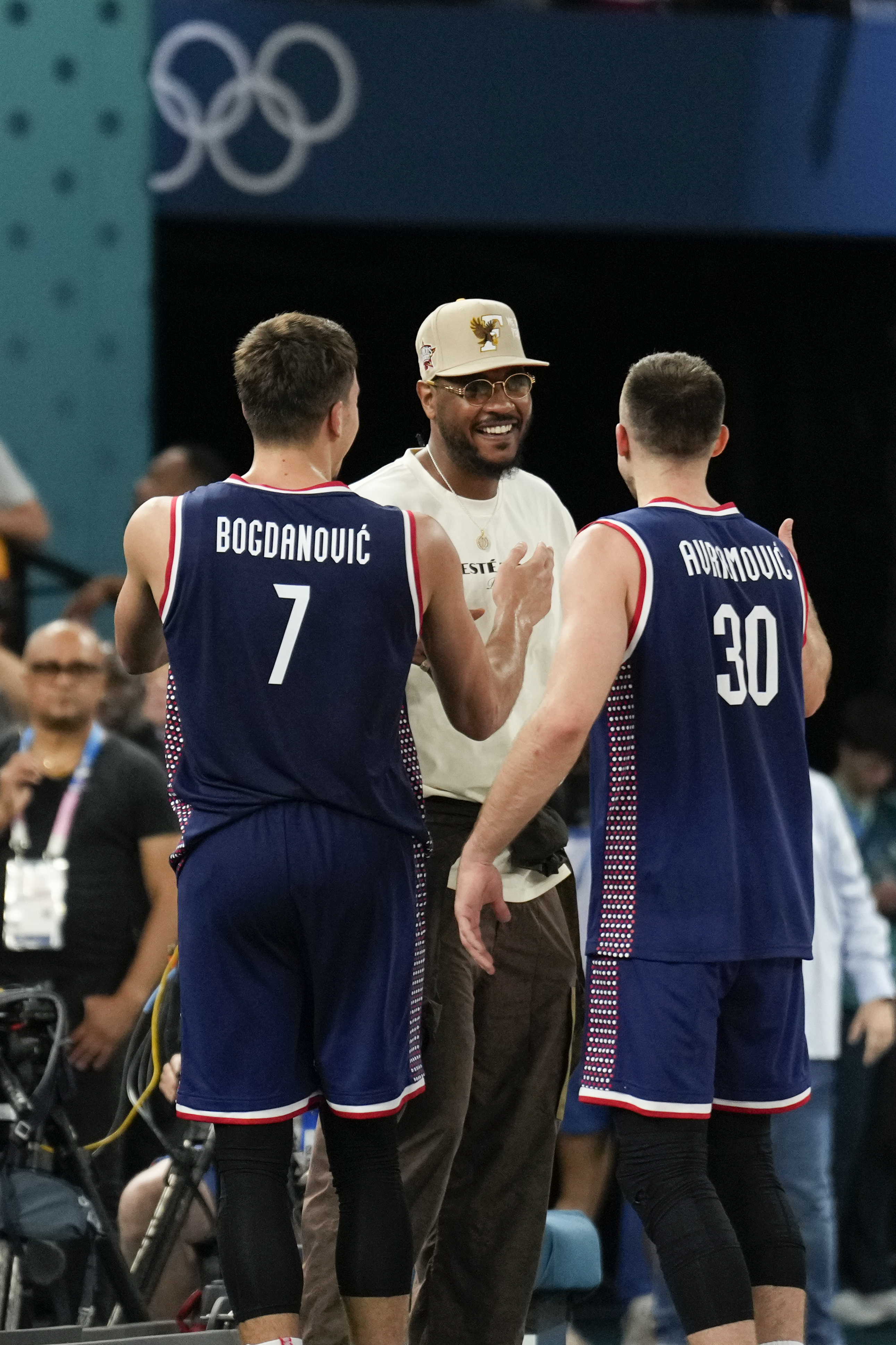 Bogdan Bogdanovic (7), of Serbia and Aleksa Avramovic (30), of Serbia greet Carmelo Anthony after Serbia beat Germany during a men's bronze medal basketball game at Bercy Arena at the 2024 Summer Olympics, Saturday, Aug. 10, 2024, in Paris, France. 