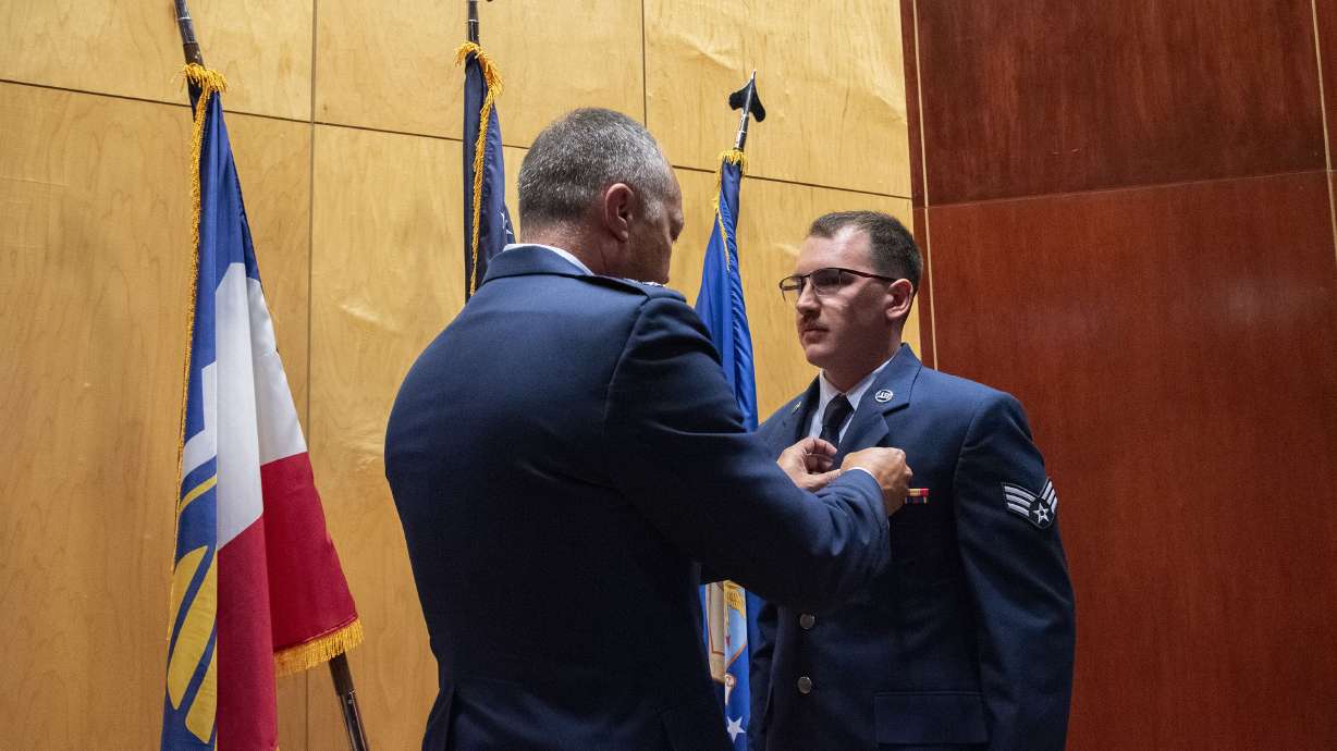 Maj. Gen. Daniel Boyack pins the Airman's Medal on Airman 1st Class Jacob Teel at a ceremony Aug. 4.