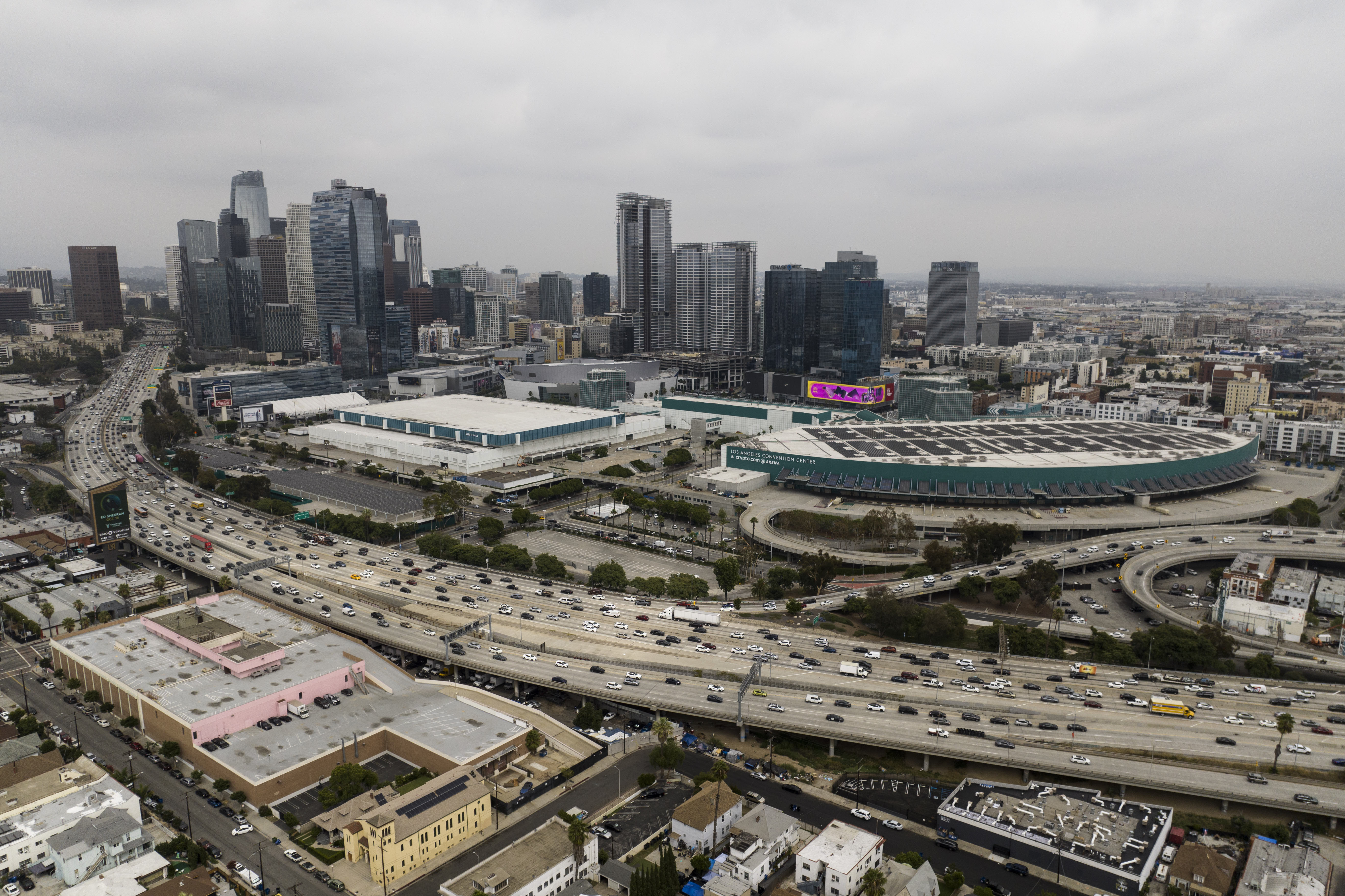 FILE - This aerial view shows traffic moving along the 110 Freeway past the Los Angeles Convention Center in Los Angeles, Tuesday, Sept. 5, 2023. As the Olympics close in Paris, Los Angeles will take the torch. The city will become the third city to host the games three times as it adds 2028 to the locally legendary years of 1932 and 1984. 