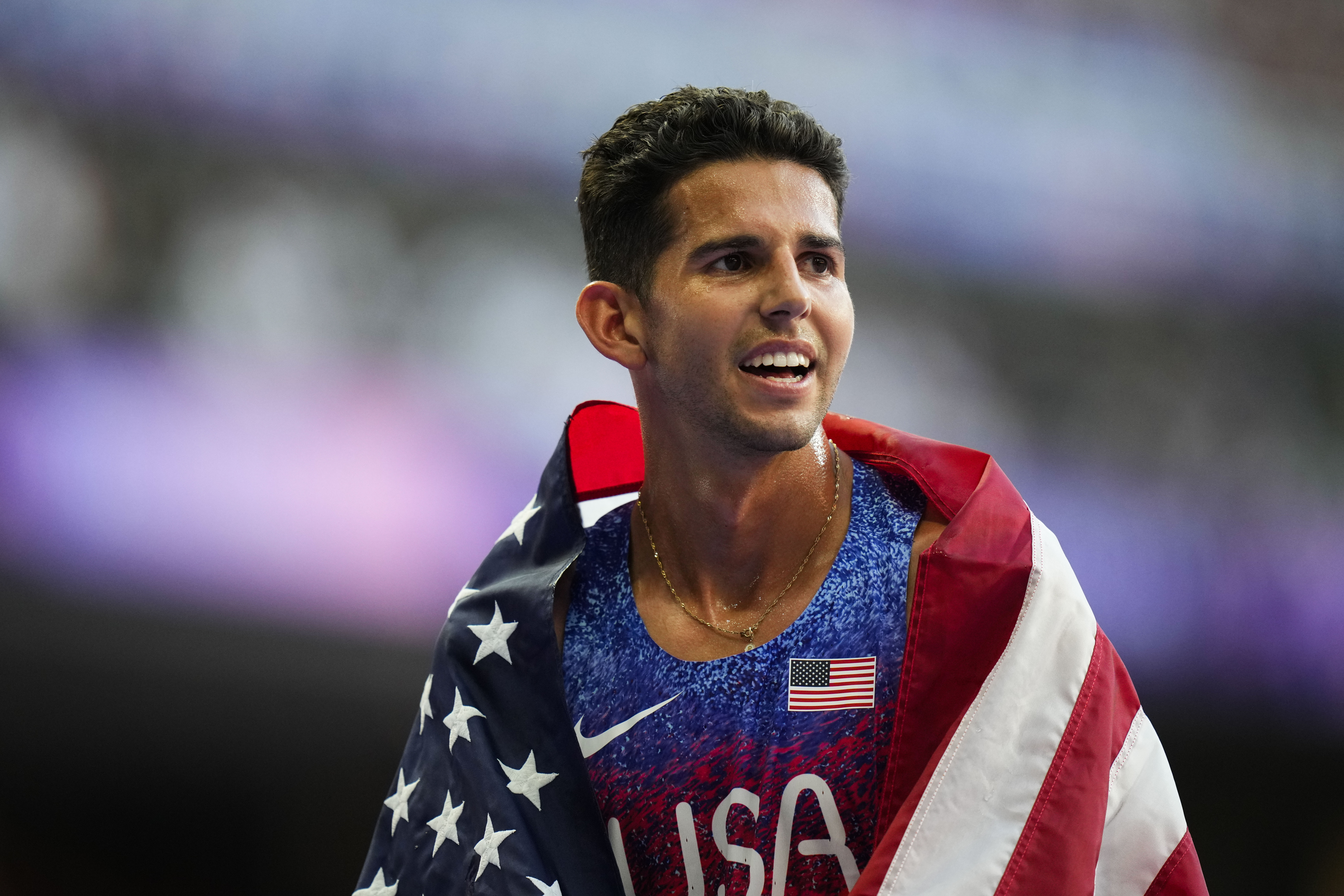 Grant Fisher, of the United States, celebrates after winning a bronze medal in the men's 5000-meter final at the 2024 Summer Olympics, Saturday, Aug. 10, 2024, in Saint-Denis, France.