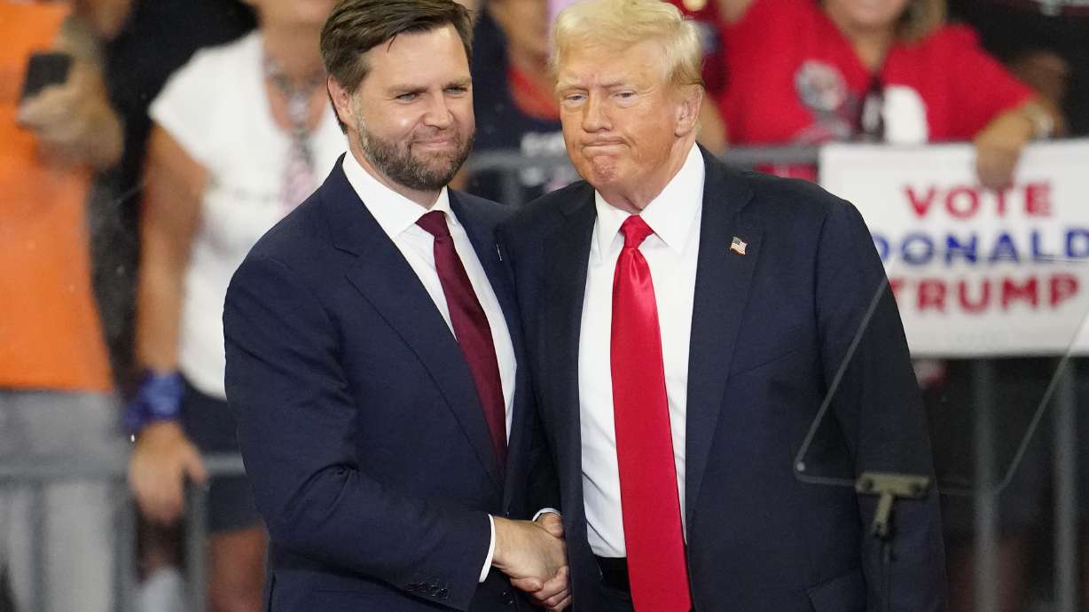 Republican vice presidential candidate Sen. JD Vance and Republican presidential candidate former President Donald Trump shake hands at a rally at Georgia State University in Atlanta, Aug. 3. Trump's presidential campaign says it has been hacked.