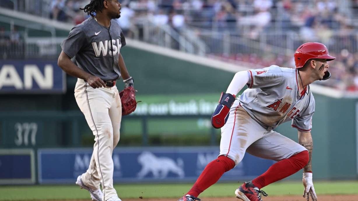 Washington Nationals third baseman Jose Tena, left, watches as Los Angeles Angels' Zach Neto turns back to second base when a fly ball by Angels' Kevin Pillar was caught, resulting in a double play, to end the third inning of a baseball game, Saturday, Aug. 10, 2024, in Washington.