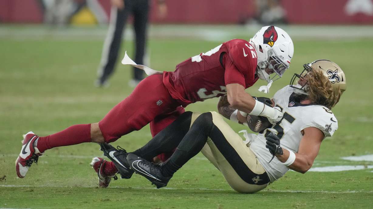 New Orleans Saints tight end Dallin Holker is tackled by Arizona Cardinals safety Joey Blount in the first half of a preseason NFL football game, Saturday, Aug. 10, 2024, in Glendale, Ariz.