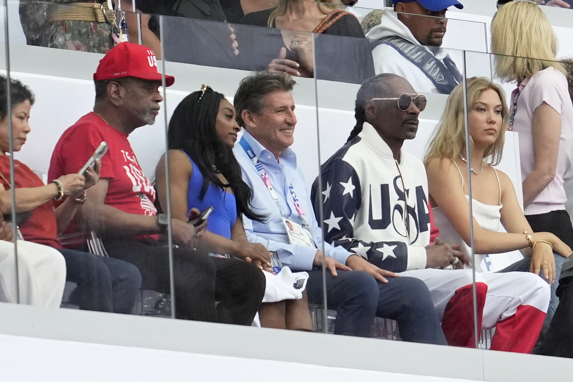 Gymnast Simone Biles, 3rd left, with her parents, sits next to IAAF president Sebastian Coe, and artist Snoop Dogg to watch an athletics session at the 2024 Summer Olympics, Thursday, Aug. 8, 2024, in Saint-Denis, France. 
