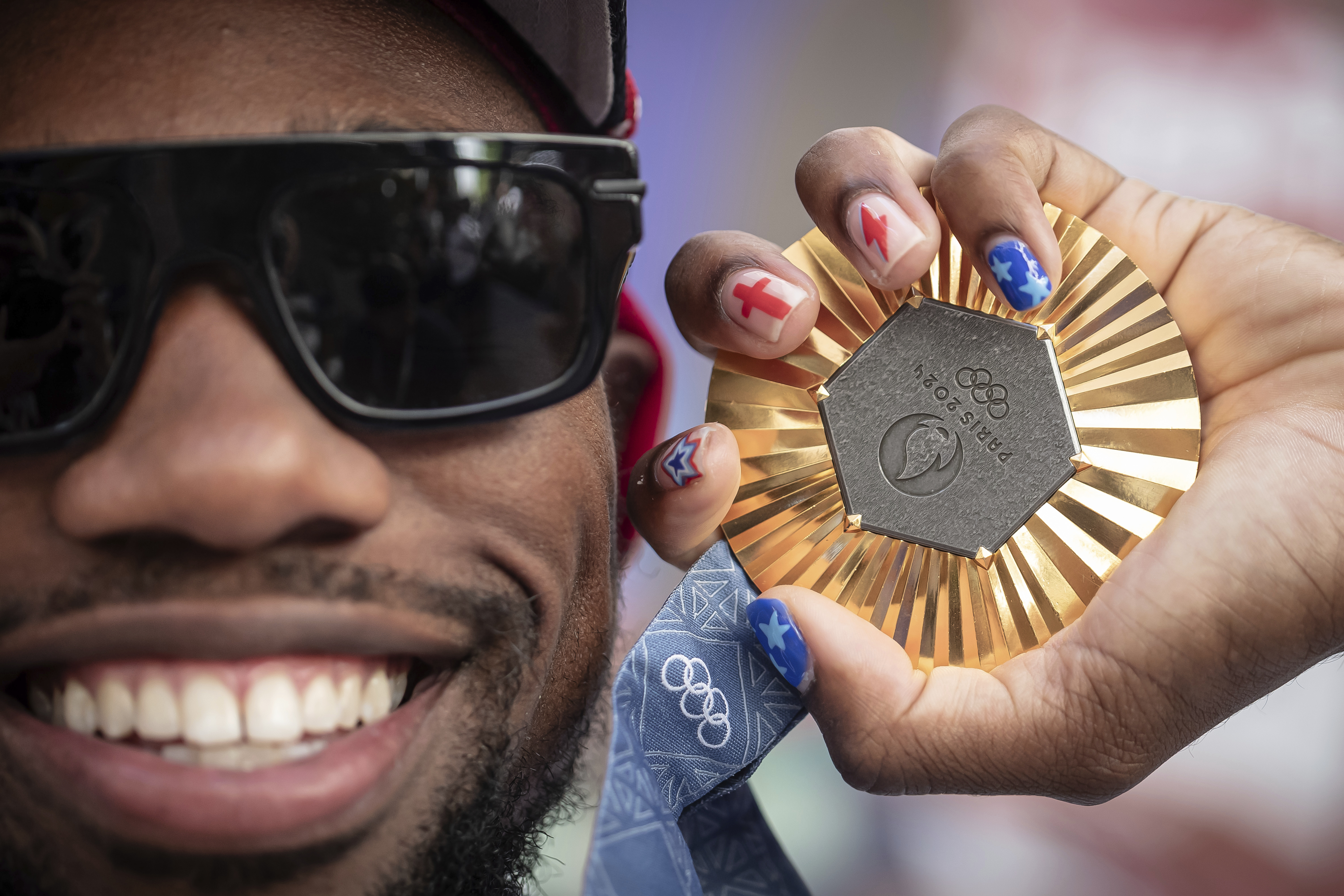 American Olympic champion Noah Lyles poses with this gold medal before an interview in Paris, France, Sunday, Aug. 11, 2024. 