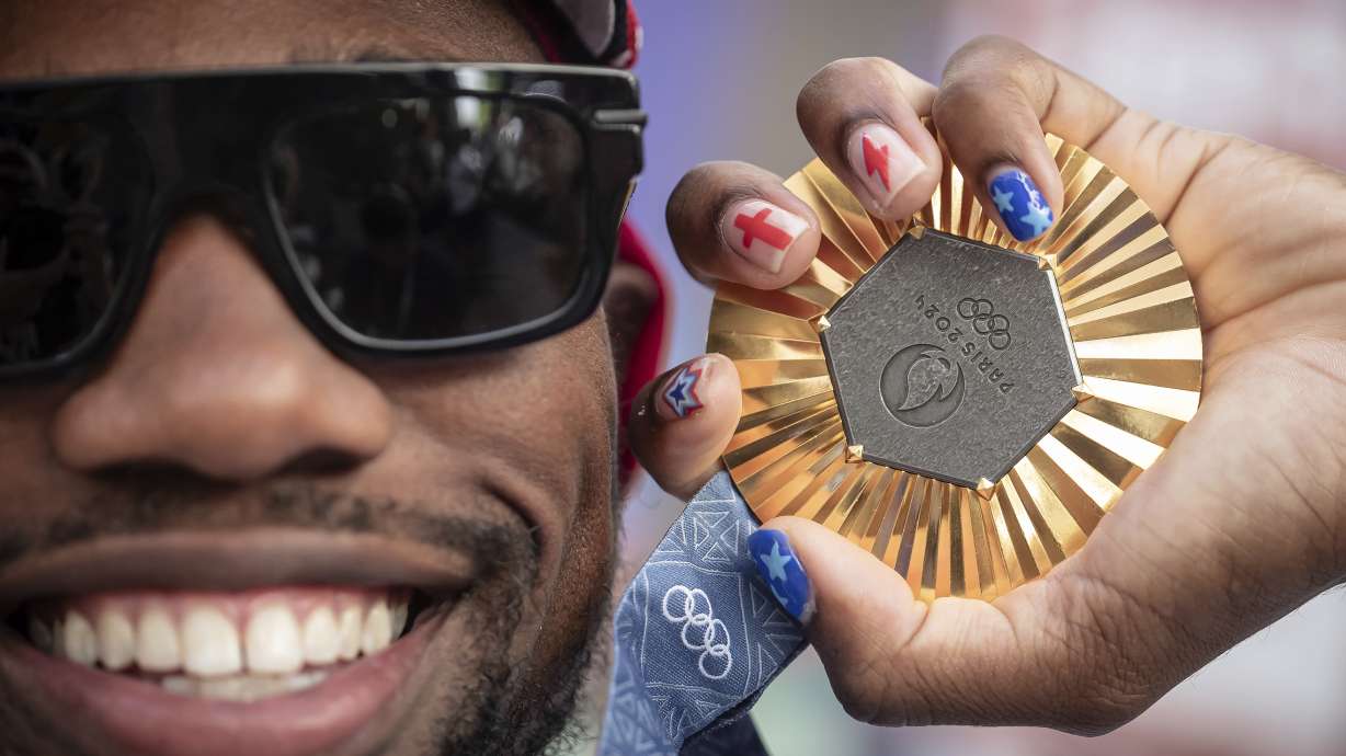 American Olympic champion Noah Lyles poses with this gold medal before an interview in Paris, France, Sunday, Aug. 11, 2024.