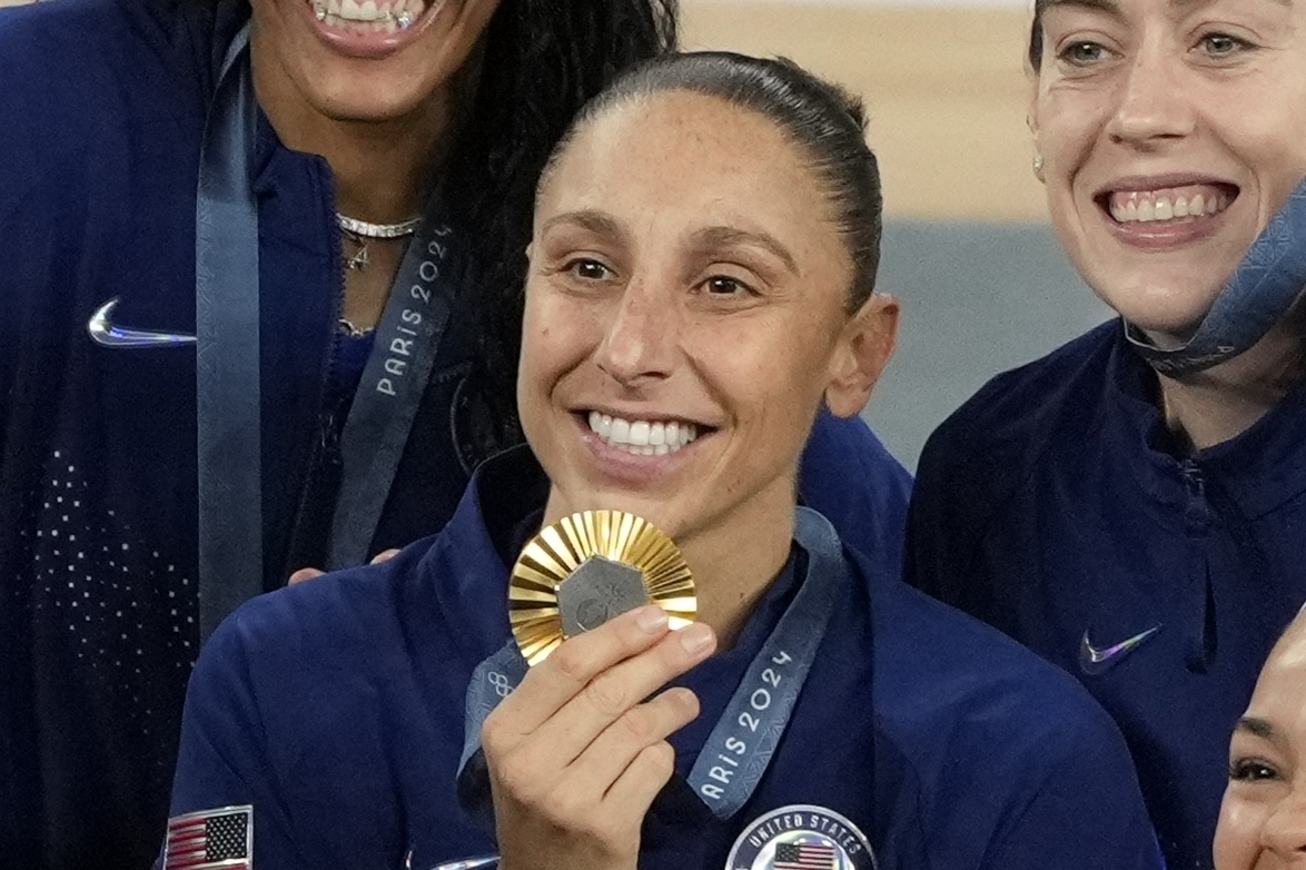 United States' Diana Taurasi (12) poses for a picture with her gold medal at Bercy Arena at the 2024 Summer Olympics, Sunday, Aug. 11, 2024, in Paris, France. 