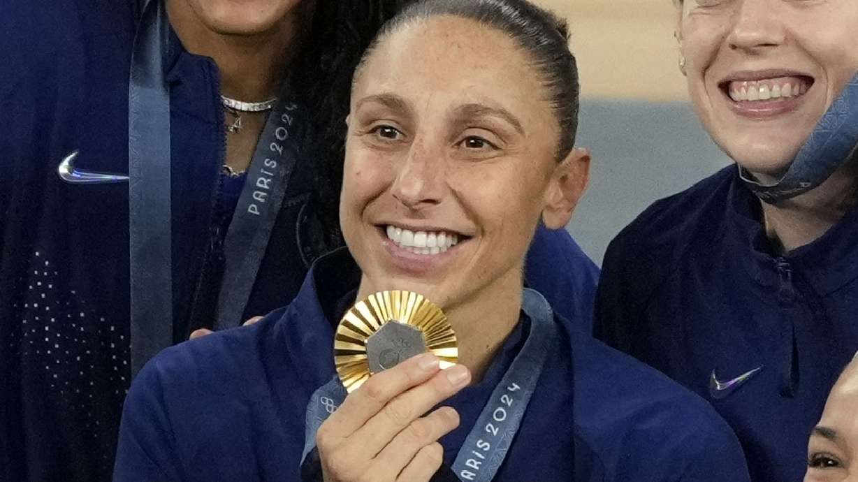 United States' Diana Taurasi (12) poses for a picture with her gold medal at Bercy Arena at the 2024 Summer Olympics, Sunday, Aug. 11, 2024, in Paris, France.